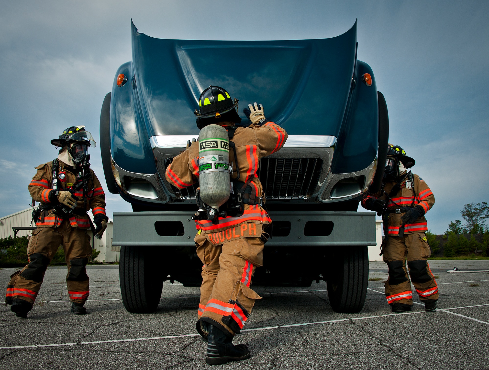 Matthew Becker, Airman 1st Class Brandon Rudolph and Amber Turek, 96th Test Wing firefighters, open up the truck hood for inspection after extinguishing a simulated truck fire during a Nuclear Accident Response Exercise at Eglin Air Force Base, Fla., Aug. 22.  Eglin agencies, including first responders, were evaluated on their reactions and responses to a vehicle explosion carrying nuclear material.  (U.S. Air Force photo/Samuel King Jr.)