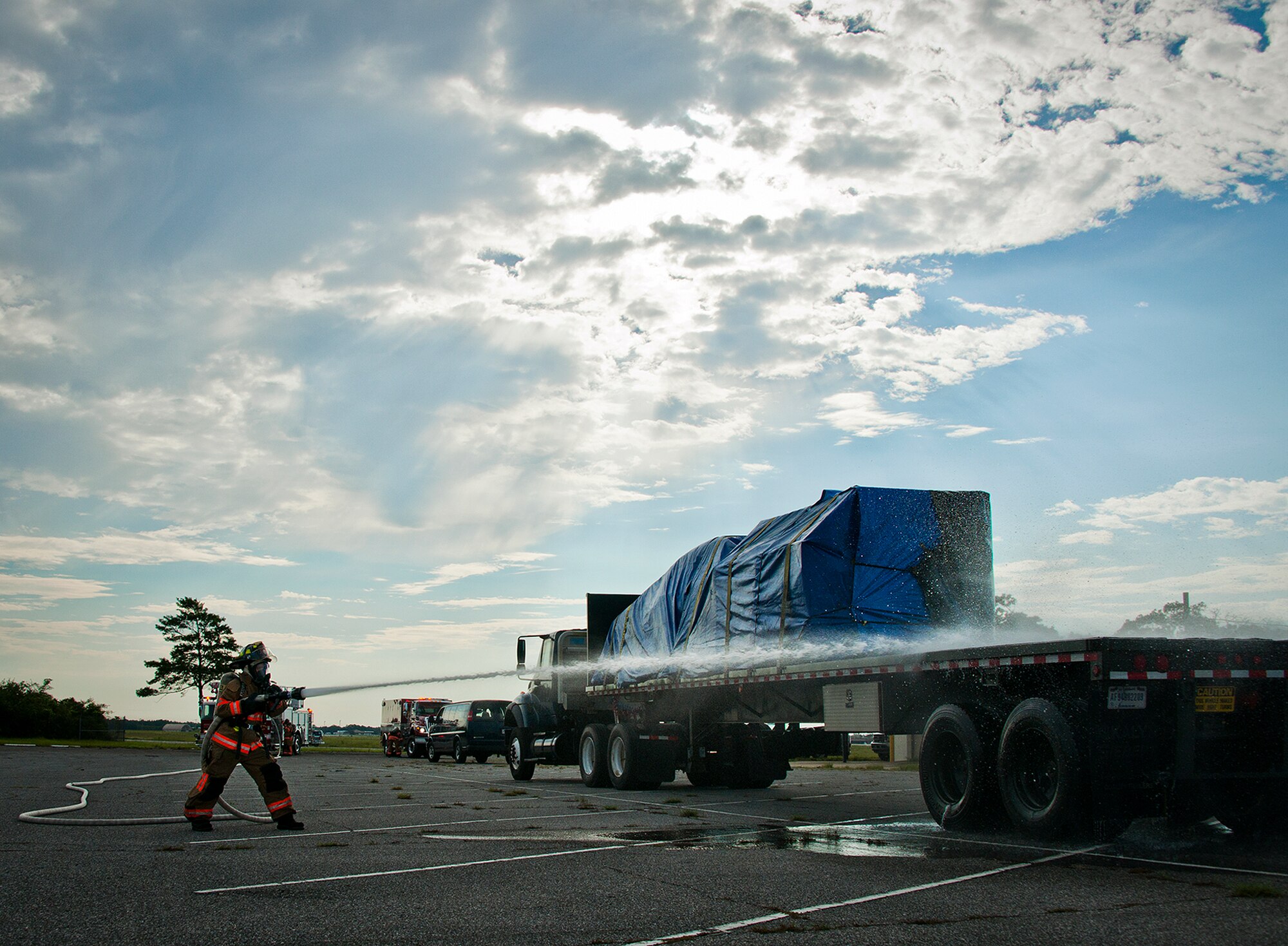 Amber Turek, a 96th Test Wing firefighter, attacks the simulated fire at the rear of the truck during a Nuclear Accident Response Exercise at Eglin Air Force Base, Fla., Aug. 22.  Eglin agencies, including first responders, were evaluated on their reactions and responses to a vehicle explosion carrying nuclear material.  Turek, was selected as the 2012 Air Force Materiel Command civilian firefighter of the year.  (U.S. Air Force photo/Samuel King Jr.) 