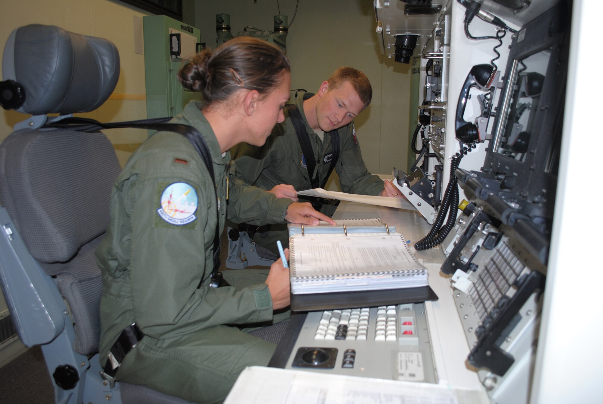 2nd Lt. Stephanie Guenther, 490th Missile Squadron deputy combat crew commander, and Capt. Brian Marlow, 490th MS ICBM combat crew commander, use their checklists while practicing possible scenarios in the missile procedures trainer. The pair of missileers will be representing the 490th MS in the upcoming Global Strike Challenge Sept. 9 to 13.  (U.S. Air Force photo/Airman 1st Class Katrina Heikkinen)