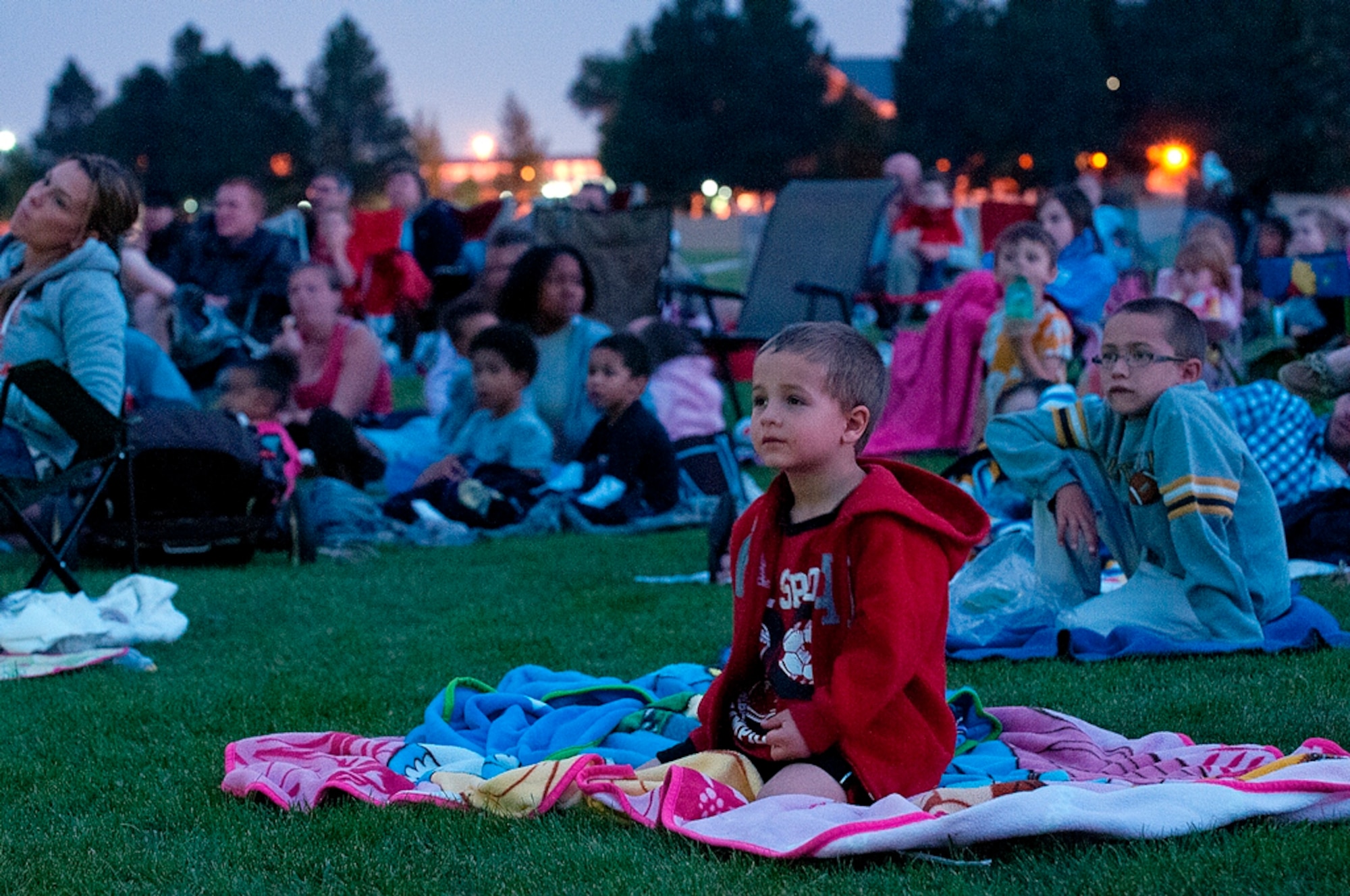 Matthew Moret, 4, son of Maj. Jay Moret, 90th Munitions Squadron commander, sits on a blanket watching “The Lorax” Aug. 17. Almost 200 members of the F. E. Warren community took advantage of the free movie, along with free refreshments, to have a night out with their families. (U.S. Air Force photo by R.J. Oriez)