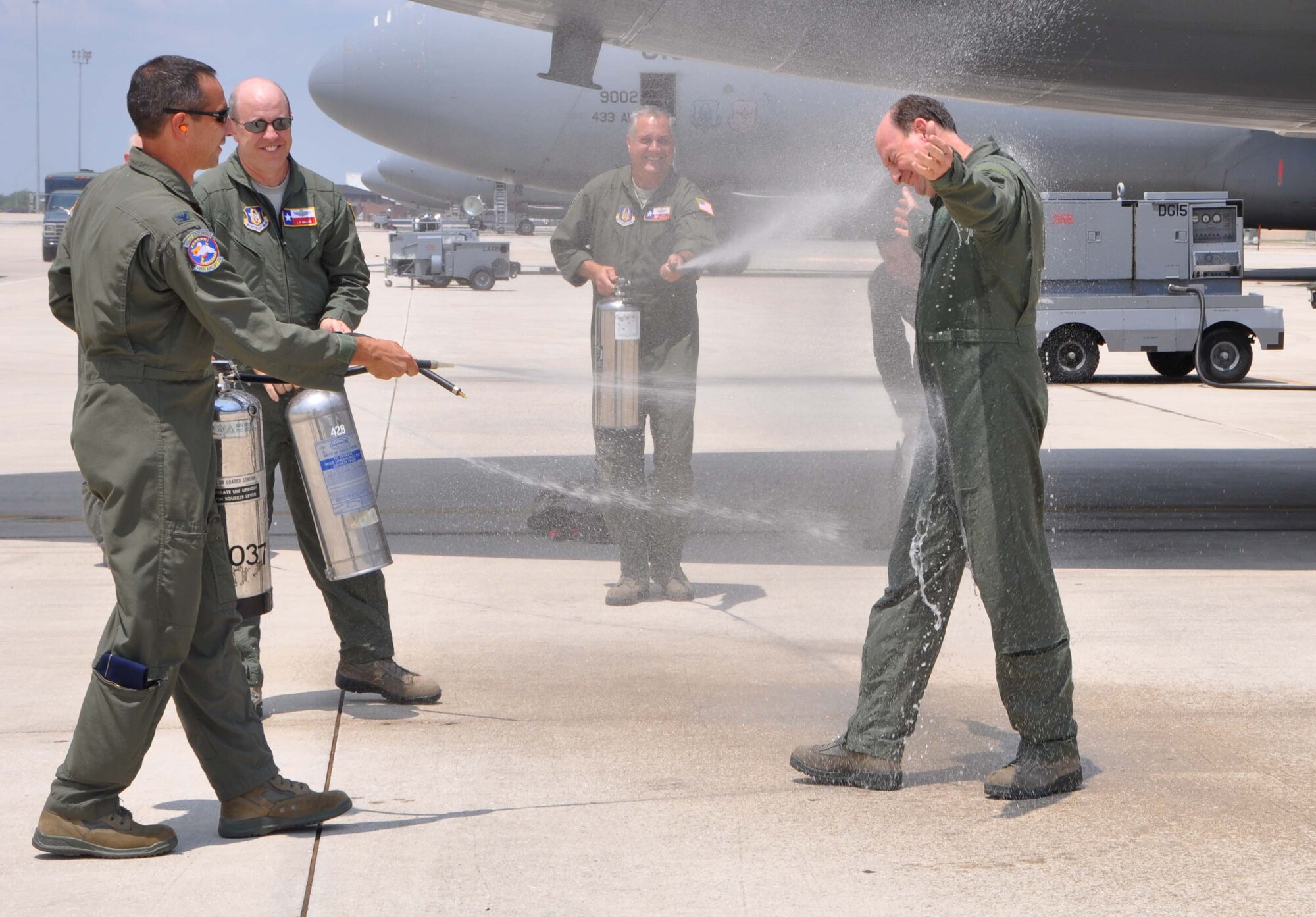 Col. Thomas K. Smith, 433rd Operations Group deputy commander, closes his eyes and accepts a friendly farewell water attack from 433rd Airlift Wing Commander Col. Jeffrey T. Pennington, Lt. Col. James C Miller, 68th Airlift Wing operations officer and Lt. Col. Jimmie P. Brooks, 433rd Operations Support Squadron commander. Colonel Smith is relocating to the 507th Air Refueling Wing at Tinker Air Force Base, Okla. to become the operations group commander.   (U.S. Air Force photo/ Senior Airman Viola M. Hernandez) 
