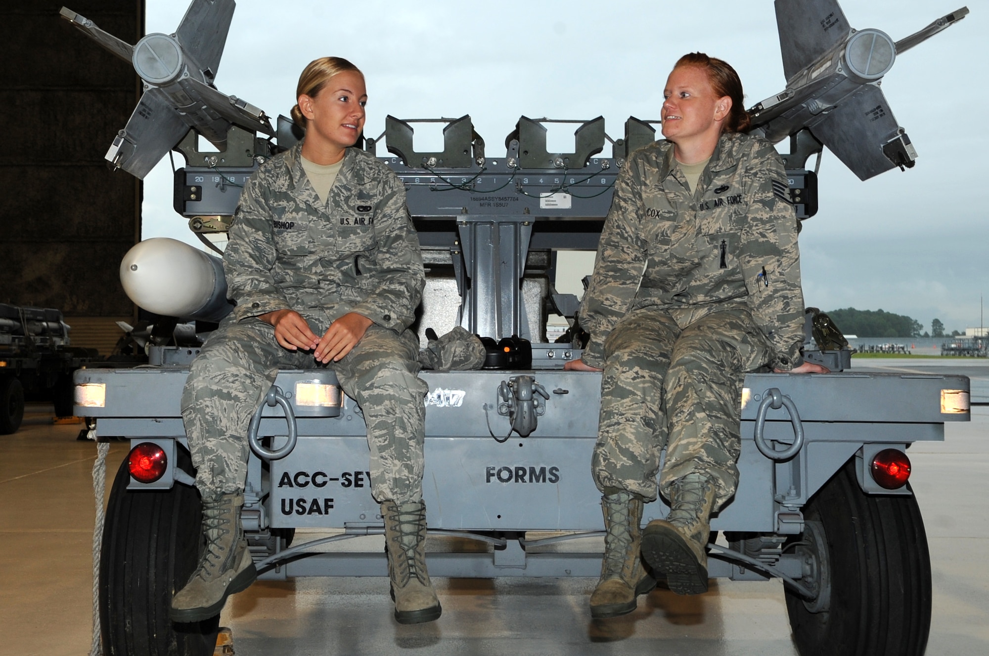 U.S. Air Force Airman 1st Class Jenna Bishop, 757th Aircraft Maintenance Squadron aircraft armament systems journeyman, Nellis Air Force Base, Nev., and Staff Sgt. Dawn Cox, 4th Maintenance Operations Squadron weapons standardization load crew member, talk between filming scenes for an Air Force Recruiting Service commercial on Seymour Johnson Air Force Base, N.C., Aug. 7, 2012. The Airmen took advantage of any breaks they were given during the two days of filming to discuss similarities in their career fields. (U.S. Air Force photo/Airman 1st Class Aubrey Robinson/Released)