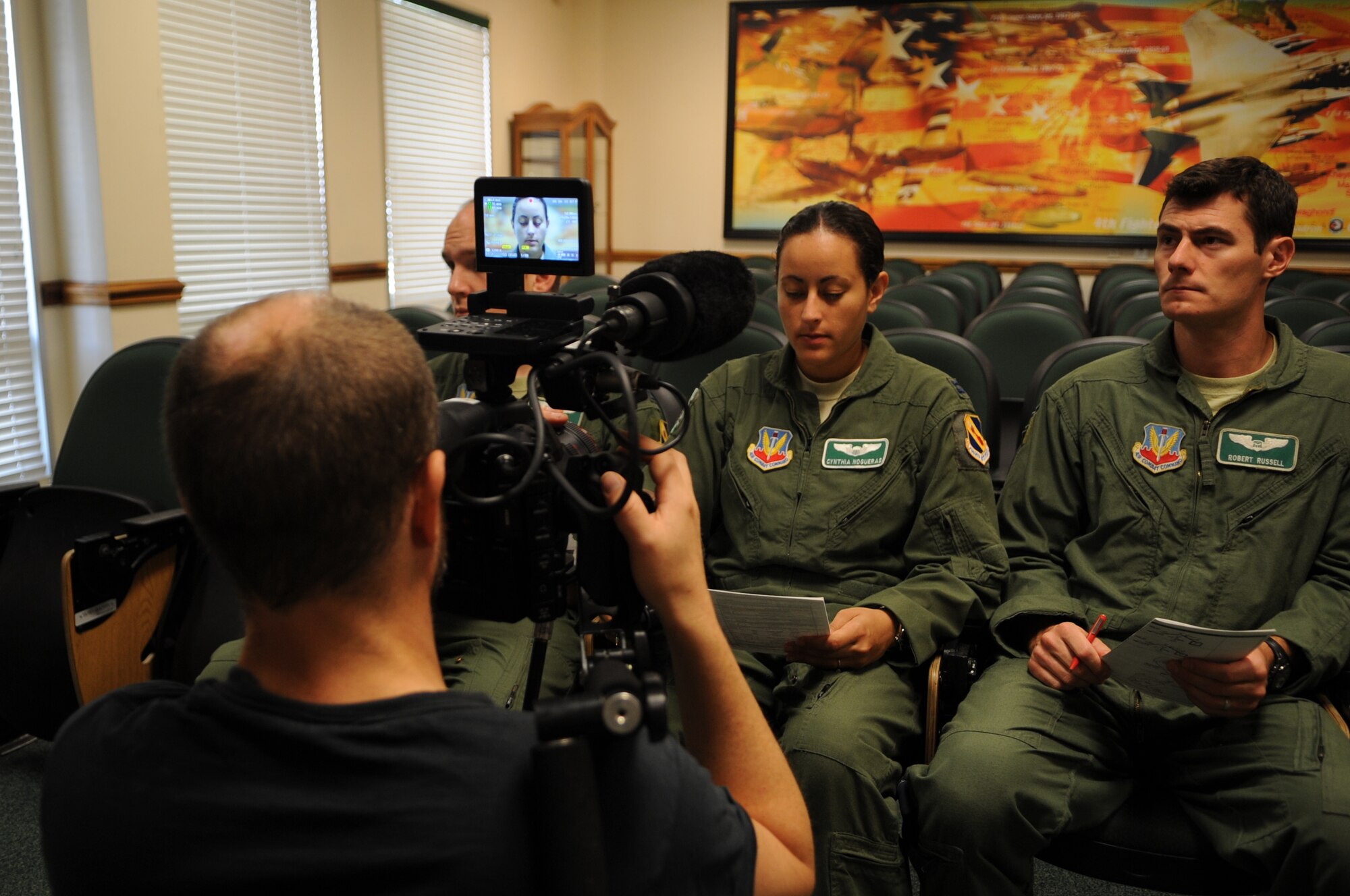 Trevor Fife, commercial director, films U.S. Air Force Airmen assigned to the 335th Fighter Squadron during a pre-flight briefing on Seymour Johnson Air Force Base, N.C., Aug. 6, 2012. Scenes for two Air Force Recruiting Service commercials were filmed at the 335th Fighter Squadron, the flight line and the Weapons Load Training Facility in order to display various career fields the Air Force has to offer. (U.S. Air Force photo/Airman 1st Class Aubrey Robinson/Released)
