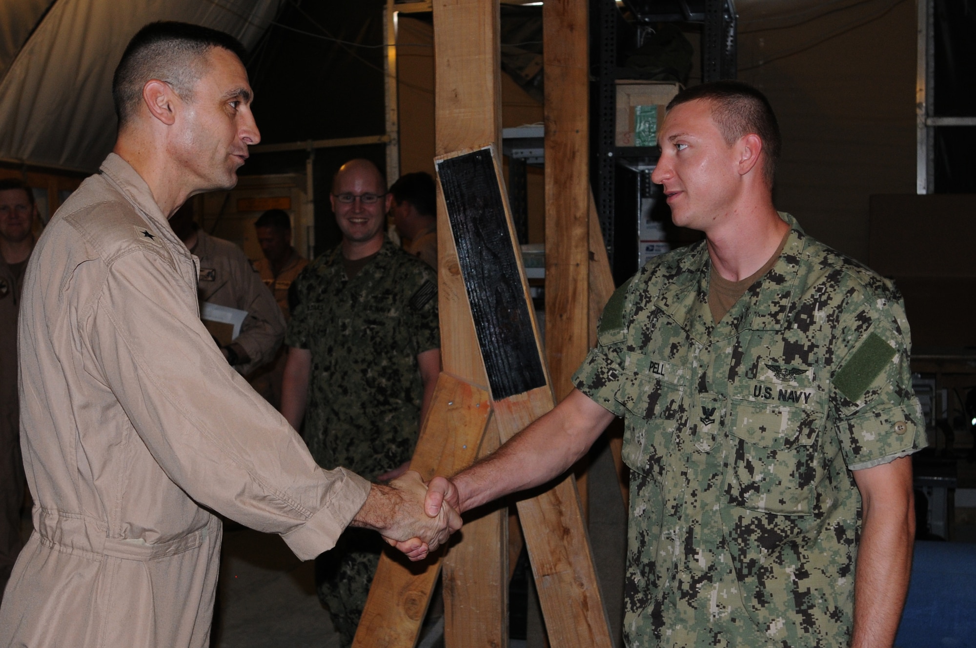 U.S. Navy Rear Admiral Matthew Carter, Patrol and Reconnaissance Force Fifth/Seventh Fleet commander coins Aviation Technician Jonathan Pell for leading a team that repaired a critical radar system restoring operability to the mission that would have been delayed without the asset. Pell is assigned to CTG 57.2 as part of VP-46. They are based at the 379th Air Expeditionary Wing in Southwest Asia, August 15, 2012. The primary mission of CTG 57.2 is to conduct reconnaissance and maritime patrol operations throughout the 5th Fleet Area of Responsibility in support of the global war on terrorism. (U.S. Air Force photo/Captain Craig Carper)