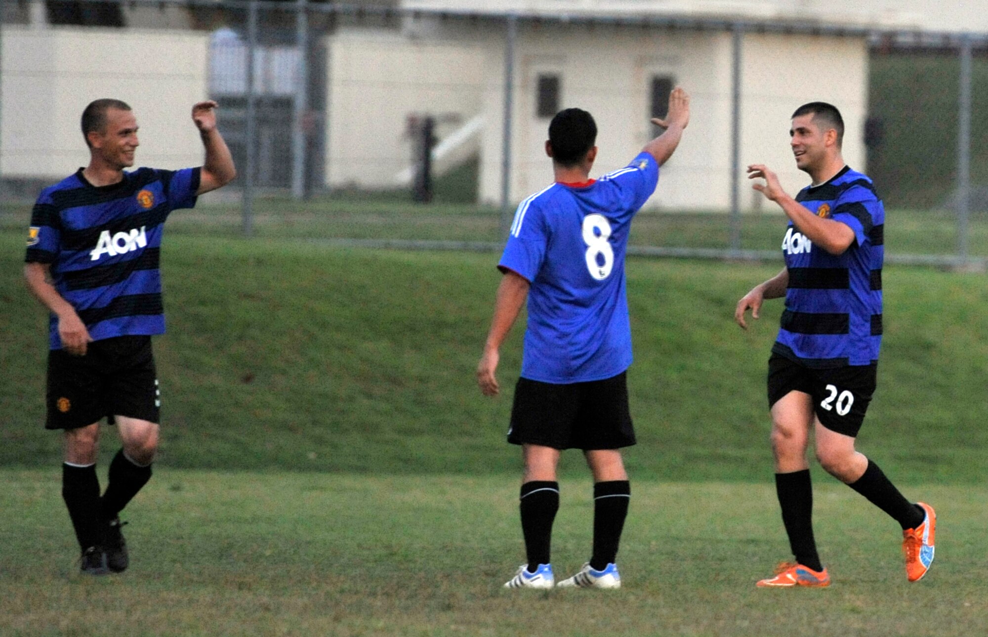 Members of the U.S. Navy Aircraft Intermediate Maintenance Department celebrate after scoring a goal during an intramural soccer game at Misawa Air Base, Japan, Aug. 21, 2012. AIMD scored the only goal of the game, which led to a hard fought 1 to 0 victory over the 35th Communications Squadron. (U.S. Air Force photo by Airman 1st Class Zachary Kee/Released)