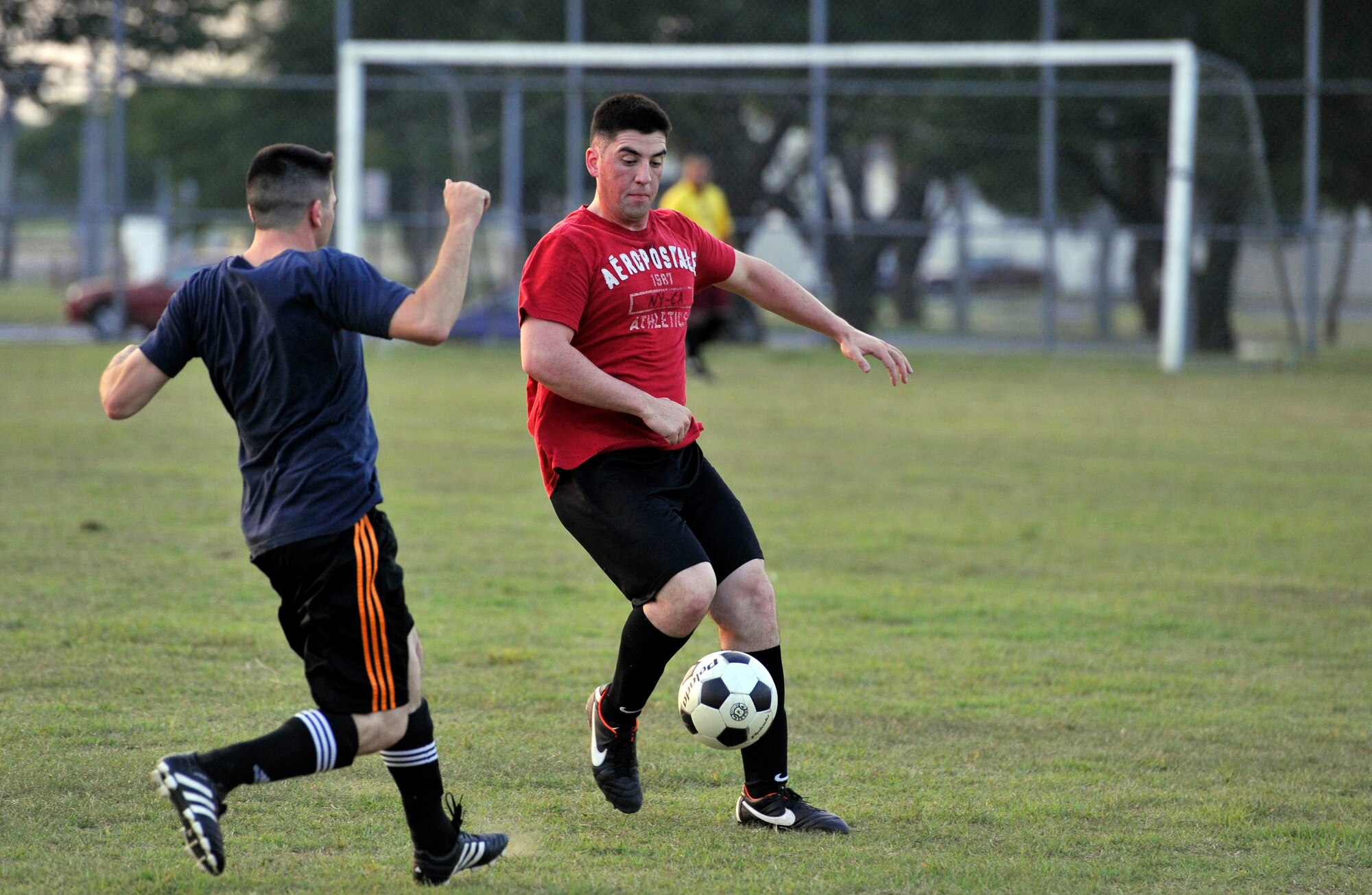 U.S. Air Force Senior Airman Jacob Lucarelli, right, 35th Communications Squadron, and U.S. Navy Petty Officer 2nd Class Joseph Laboy, Aircraft Intermediate Maintenance Department, fight for possession of the ball during an intramural soccer game at Misawa Air Base, Japan, Aug. 21, 2012. After a hard fought match by both teams, AIMD came out on top of the 35 CS by a score of to 1 to 0. (U.S. Air Force photo by Airman 1st Class Zachary Kee/ Released)