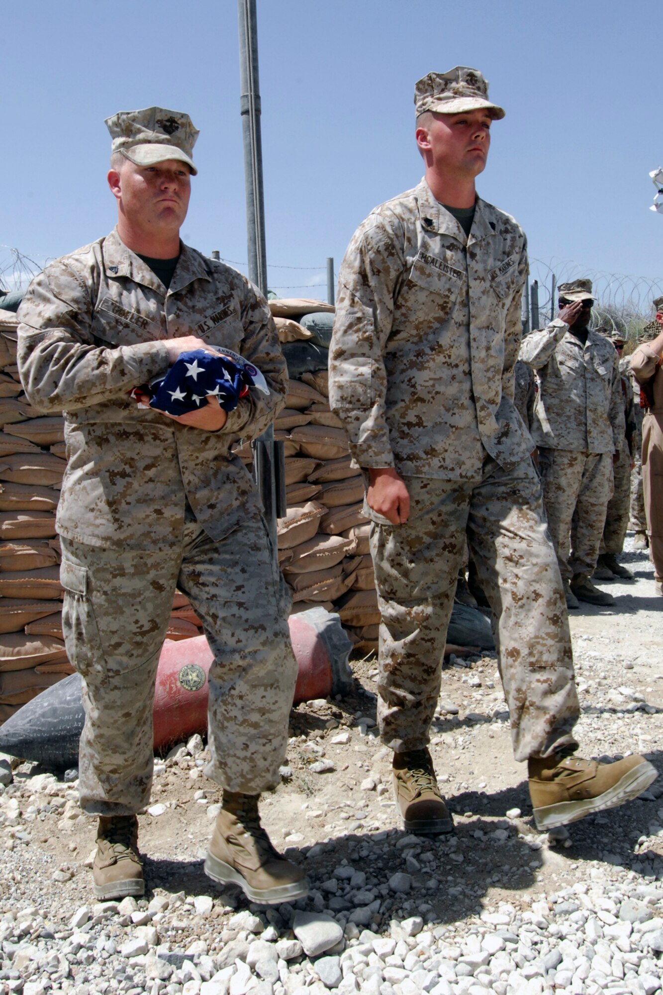Cpl. Eric Gufler (left) and Sgt. Shawn McAllister, both assigned to the Marine Tactical Electronic Warfare Squadron-2, perform honor guard details as the American flag was lowered a final time during the Camp McCool closing ceremony at Bagram Airfield, Afghanistan, Aug. 8, 2012. The camp was named after U.S. Navy Commander William C. McCool, a space shuttle astronaut who perished when the shuttle “Columbia” broke up during reentry into Earth’s atmosphere 16 minutes before its scheduled landing. Camp McCool was opened shortly after CMDR McCool’s death. The camp had been home to the Marine Corps Prowler community since 2009. (U.S. Air Force photo/SSgt Jeff Nevison)