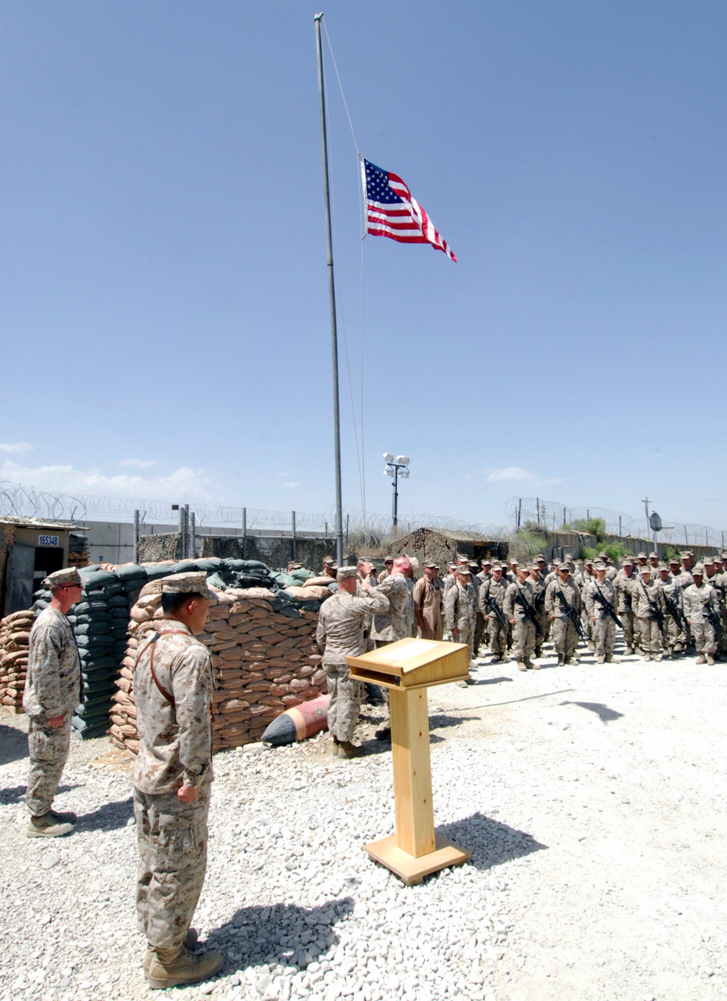 U.S. Marines of the Marine Tactical Electronic Warfare Squadron-2 pay respect to the “Stars & Stripes” as they are lowered for the final time during the Camp McCool closing ceremony at Bagram Airfield, Afghanistan, Aug. 8, 2012. The camp was named after U.S. Navy Commander William C. McCool, a space shuttle astronaut who perished when the shuttle “Columbia” broke up during reentry into Earth’s atmosphere 16 minutes before its scheduled landing. Camp McCool opened up shortly after CMDR McCool’s death. The camp had been home to the Marine Corps Prowler community since 2009. (U.S. Air Force photo/SSgt Jeff Nevison)