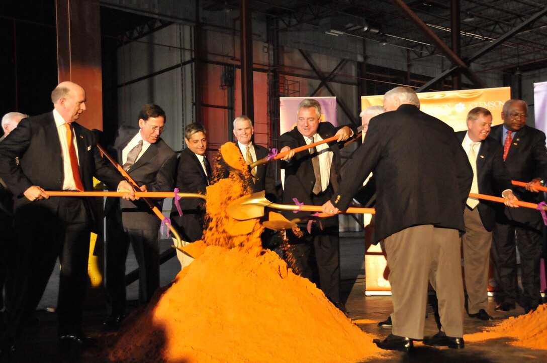 Delegates and stakeholders turn over orange sand to signify the groundbreaking of the new wind facility at Clemson University.