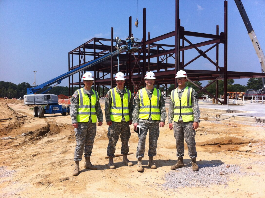 Standing in front of construction of the Training Aids Support Center.