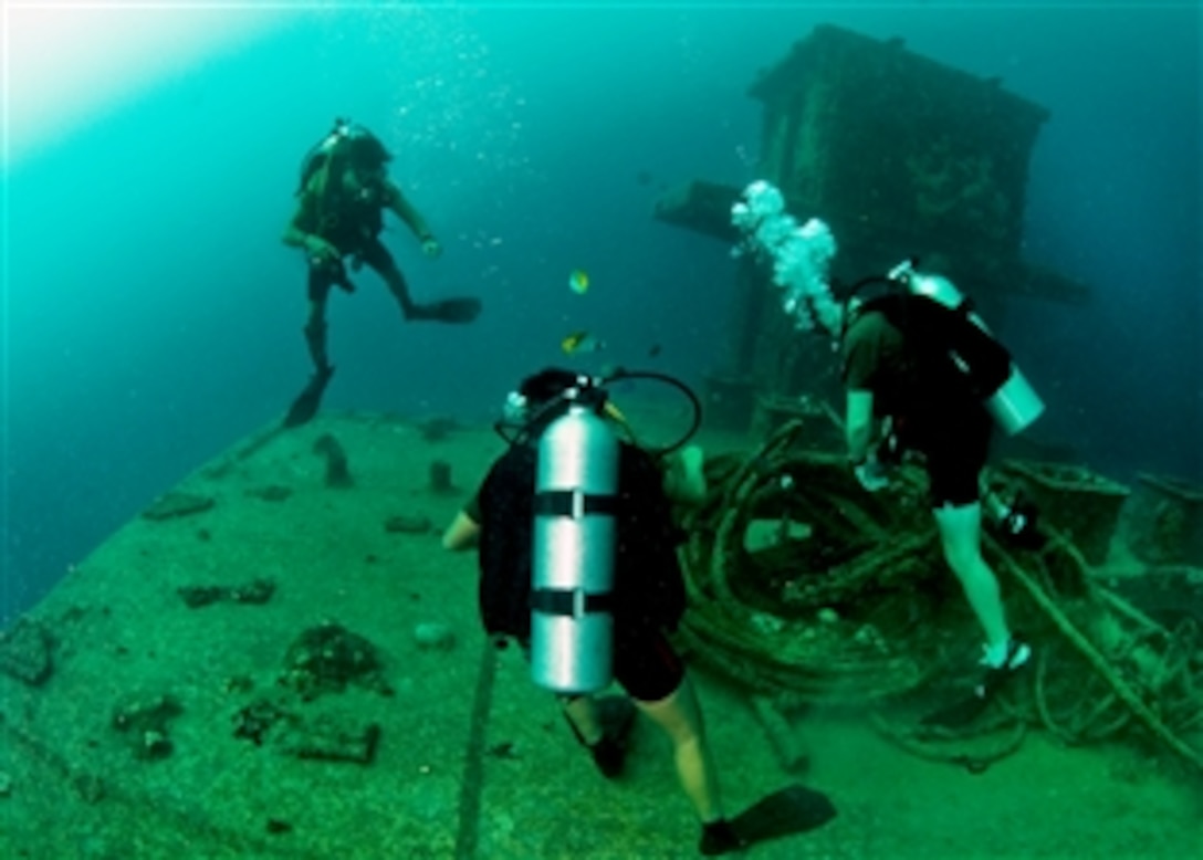 U.S. Navy Petty Officer 2nd Class Justin Westbrook, right, and Singapore navy explosive ordnance disposal technicians conduct a familiarization dive during Tricrab 2012 in Guam, Aug. 23, 2012. The exercise focuses on strengthening relationships within the Asia-Pacific region through training and information exchanges to enhance disposal and diving related interoperability. Westbrook is a technician assigned to Explosive Ordnance Disposal Mobile Unit 5.