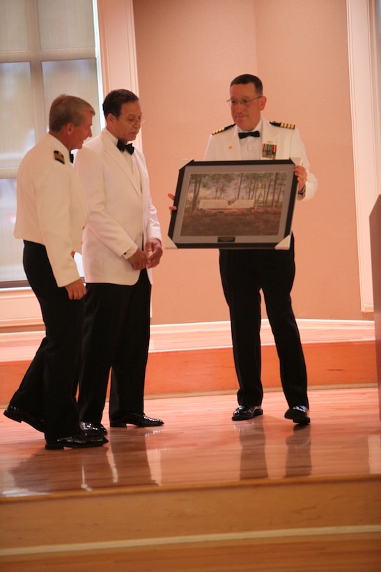 Navy Capt. Francisco R. Leal (right), the commanding officer of 2nd Dental Battalion, 2nd Marine Logistics Group, presents a picture of the Beirut Memorial to Navy Captains James J. Ware(left) and Gilbert Bigelow (middle), two retired dental officers, during the Navy’s Dental Corps’ 100th anniversary ball aboard Camp Lejeune, N.C., Aug. 18, 2012. Ware and Bigelow provided medical assistance to troops during the Beirut attack and were the guests of honor for the ball. 