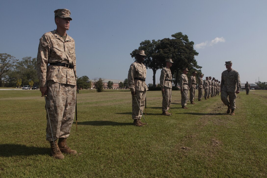 Sgt. Stephen W. Ford, an instructor for Cherry Point Corporals Leadership Course, walks down the line of students and inspects their "order sword" during an introduction to sword manual, Aug. 17. The three-week course is the first Professional Military Education class enlisted Marines attend and focuses on leadership, history and tradition of Marine Corps corporals.