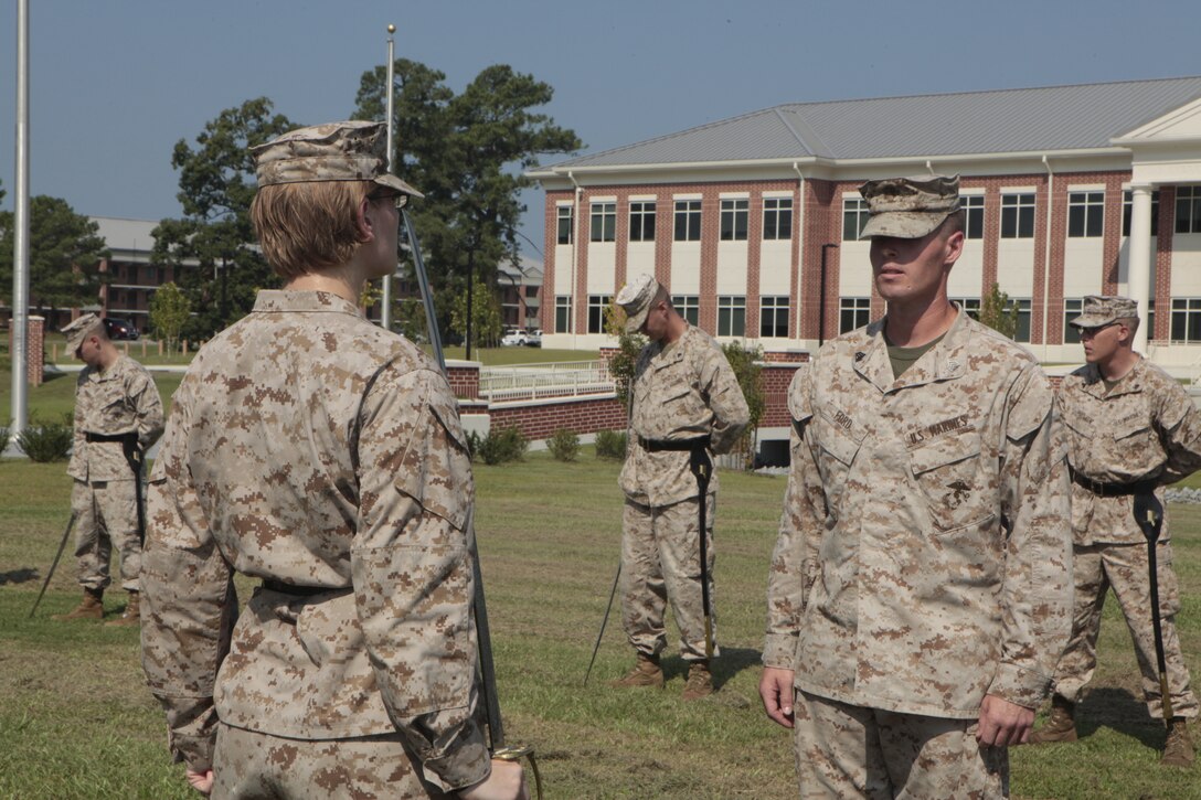 Sgt. Stephen W. Ford, an instructor for Cherry Point Corporals Leadership Course, inspects Cpl. Tammy K. Hineline, a combat videographer with Marine Wing Headquarters Squadron and student with class 274-12, during an introduction to sword manual, Aug. 17. The three-week course is the first Professional Military Education class enlisted Marines attend and focuses on leadership, history and tradition of Marine Corps corporals.