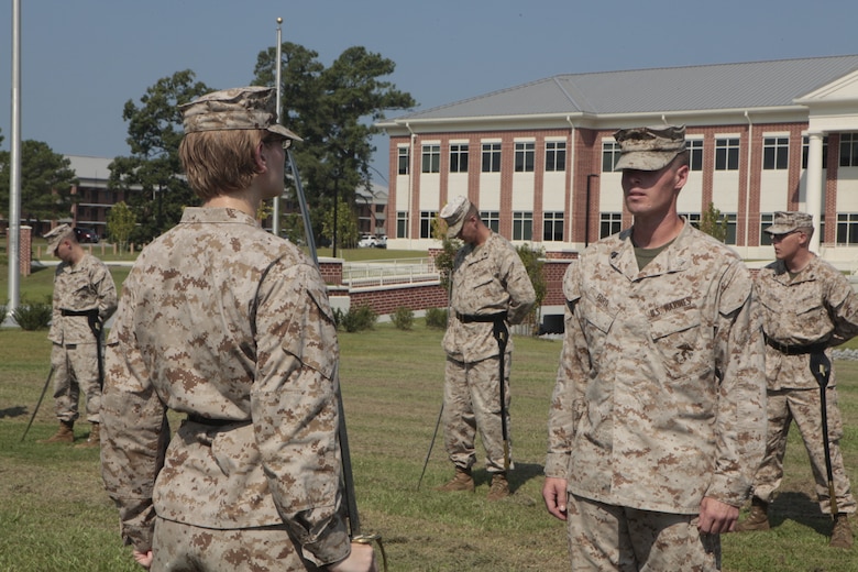 Sgt. Stephen W. Ford, an instructor for Cherry Point Corporals Leadership Course, inspects Cpl. Tammy K. Hineline, a combat videographer with Marine Wing Headquarters Squadron and student with class 274-12, during an introduction to sword manual, Aug. 17. The three-week course is the first Professional Military Education class enlisted Marines attend and focuses on leadership, history and tradition of Marine Corps corporals.