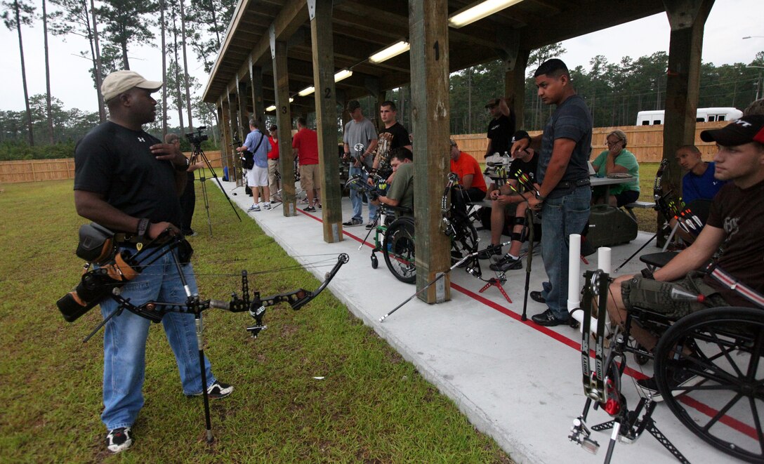 Marines with Wounded Warrior Battalion-East and -West listen to a coach during the WW Regiment archery camp aboard Marine Corps Base Camp Lejeune Aug. 20 through 25. Approximately 40 wounded warriors participated in the week-long camp where coaches assisted in improving and refining their shooting technique.