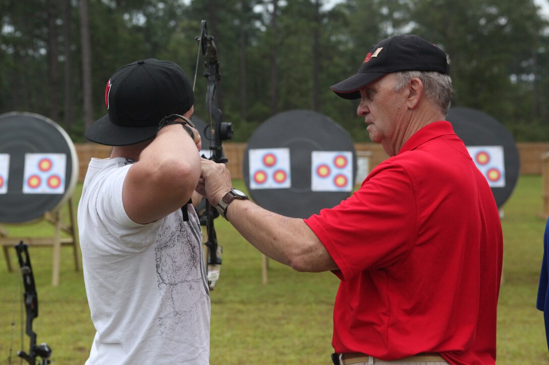 A Marine with the Wounded Warrior Regiment listens to a coach during the WWR archery camp aboard Marine Corps Base Camp Lejeune Aug. 21. The camp is a component of WWR’s Warrior Athlete Reconditioning program, which helps the service members develop camaraderie and do something different outside their daily routine.