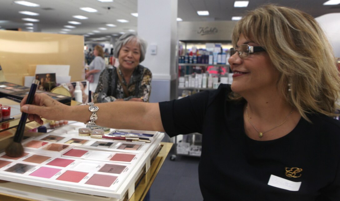 Colette "CoCo" Klotz dusts a block of color with the right brush demonstrate a technique at the Marine Corps Exchange aboard Marine Corps Base Camp Lejeune Aug. 17. Klotz has in the make-up business for over a decade and enjoys using her experience as a military spouse to make her customers feel beautiful inside and out.