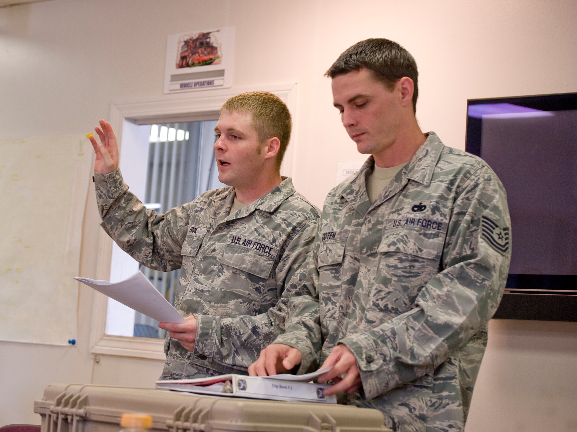 Staff Sgt. Corey Vanak, a vehicle operation control center dispatcher, left, and Tech. Sgt. Leonard Ooten, vehicle operation control center supervisor, both of 1st Special Operations Logistics Readiness Squadron, perform roll call for Airmen scheduled to transport materials at Hurlburt Field, Fla., Aug. 26, 2012. Hurlburt Field assets were being evacuated as Tropical Storm Isaac approaches the Gulf Coast region. (U.S. Air Force photo / Airman 1st Class Nigel Sandridge)