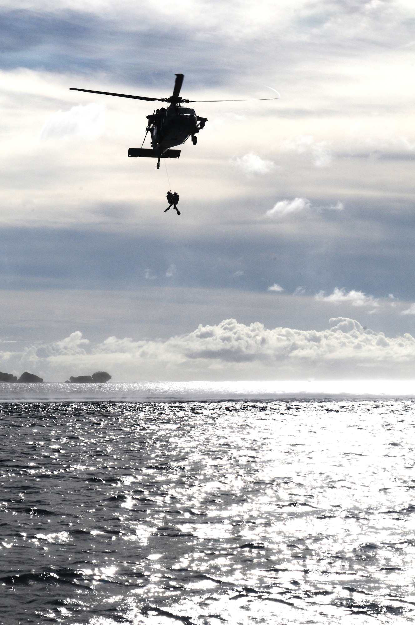 Servicemembers of Heicopter Sea Combat Squadron Two Five practice hoisting procedures during an exercise at Apra Harbor, Guam, June 14. HSC-25 servicemembers practice their skills to keep their alert posture. U.S. Air Force photo/Airman 1st Class Mariah Haddenham/Released)