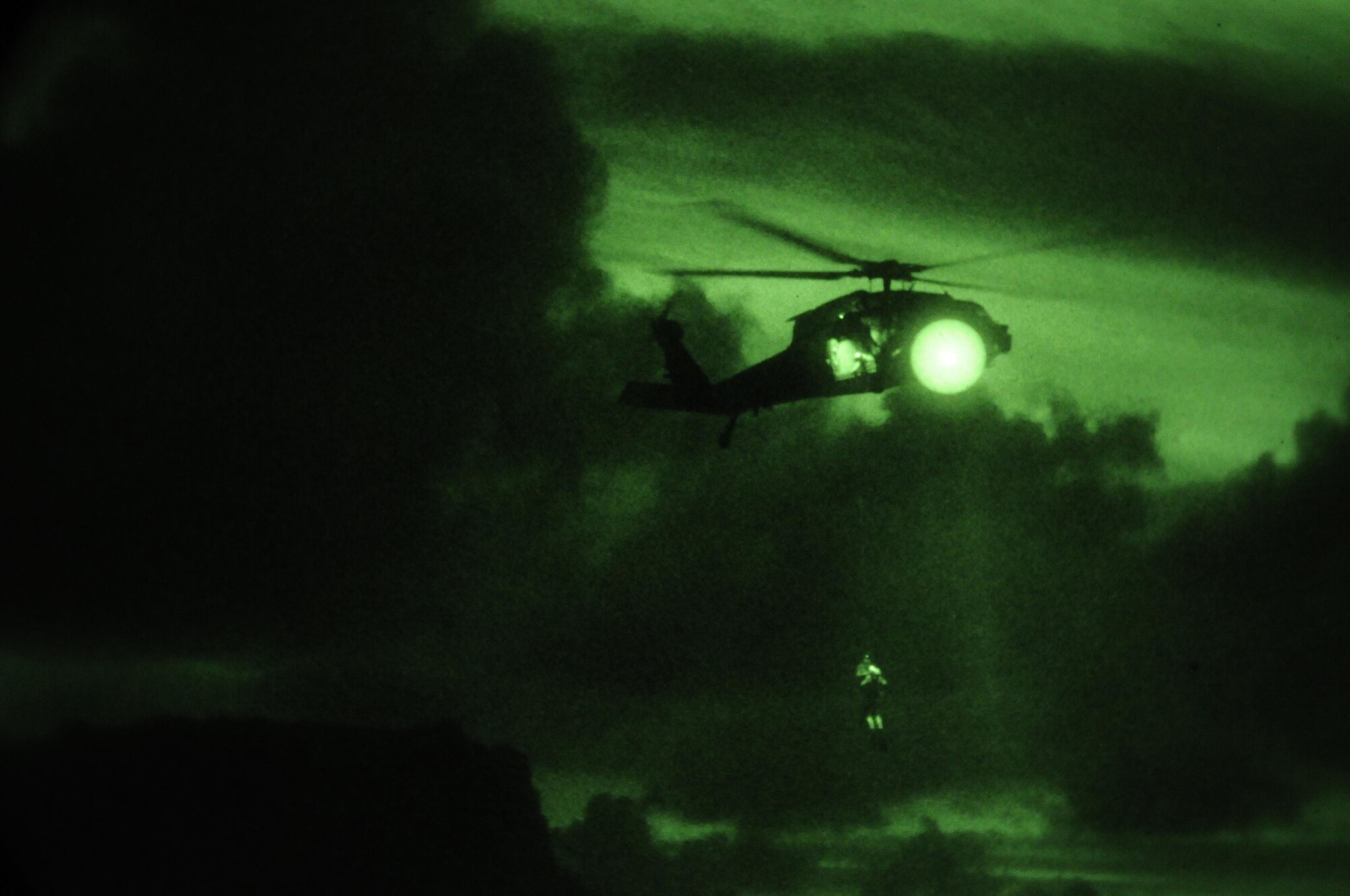 Servicemembers of Heicopter Sea Combat Squadron Two Five practice hoisting procedures during a night-time exercise at Apra Harbor, Guam, June 14. HSC-25 servicemembers practice their skills to keep their alert posture. U.S. Air Force photo/Airman 1st Class Mariah Haddenham/Released)
