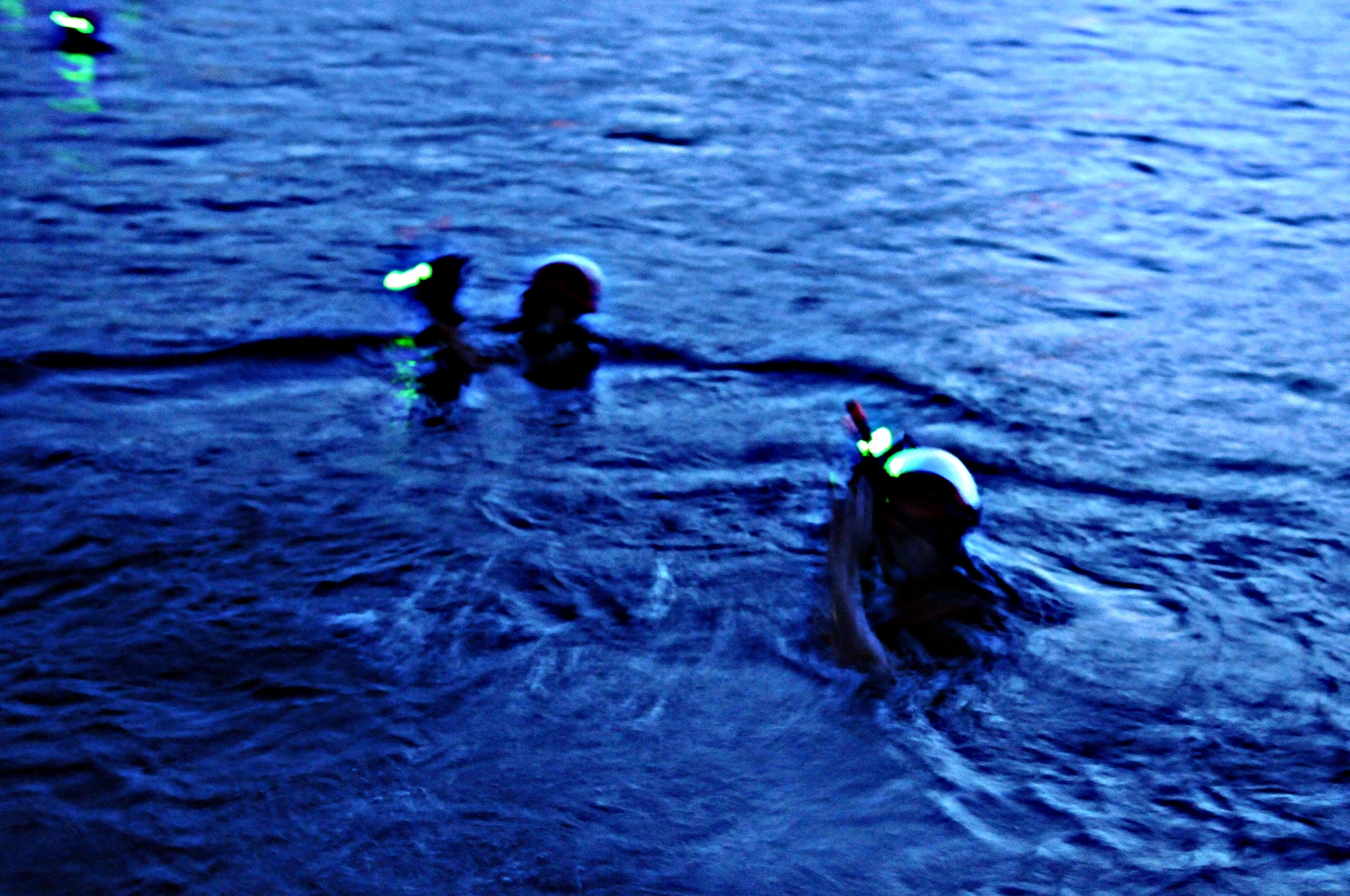 Servicemembers of Helicopter Sea Combat Squadron Two Five swim toward their target during a night-time exercise at Apra Harbor, Guam,  June 14. HSC-25 servicemembers exercise their skills, keeping themselves sharp and mission-ready. U.S. Air Force photo/Airman 1st Class Mariah Haddenham/Released)