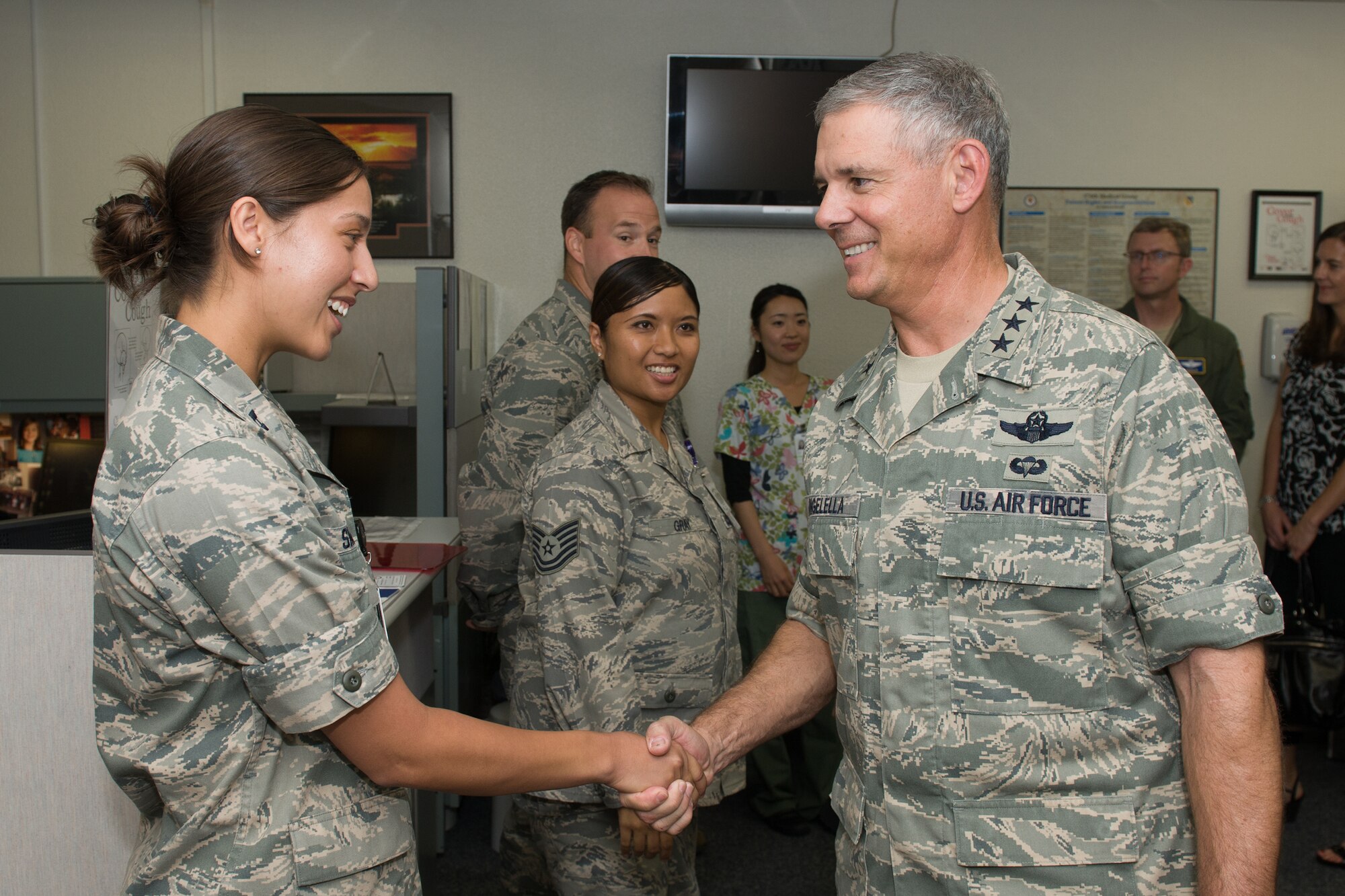 YOKOTA AIR BASE, Japan -- Lt. Gen. Sam Angelella, right, U.S. Forces, Japan, and 5th Air Force commander, presents his coin to Capt. Melissa Smith, 374th Medical Surgical Squadron officer in charge of the Obstetrics and Gynecology clinic, during a base visit, Aug. 22, 2012. During the visit, Angelella discussed manpower and clinic operations with Smith and her staff. (U.S. Air Force photo by Osakabe Yasuo)