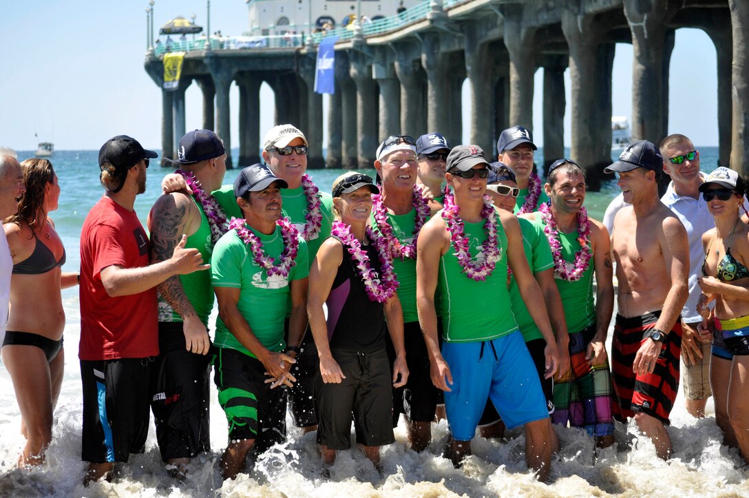 The Wounded Warrior Battalion-West paddle board team and supporters gather for group photographs in front of the Manhattan Beach Pier after finishing the Catalina Classic at Manhattan Beach, Ca., Aug. 26.
