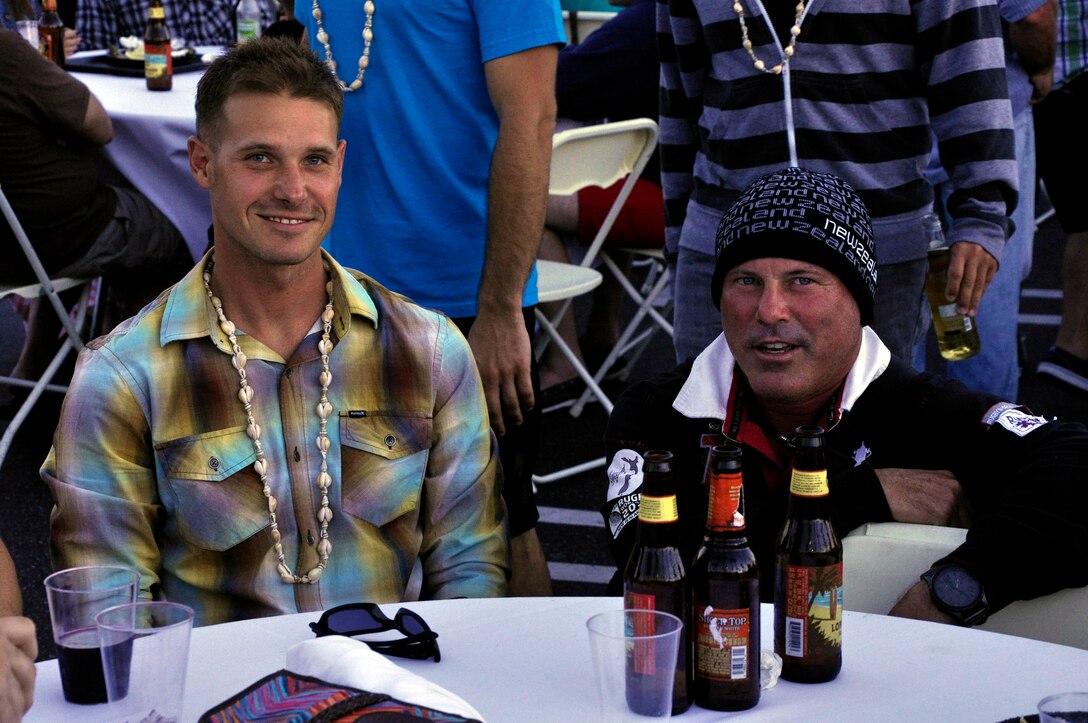 (Left to right) David McCreary, a platoon sergeant for the Wounded Warrior Battalion-West, and Joe Clark, owner of "New Star One," the boat that carried the Wounded Warrior Battalion-West paddle board team from Catalina Island to Manhattan Beach while not taking their turn paddling in the Catalina Classic paddle board race, at Manhattan Beach, Calif., Aug. 26.