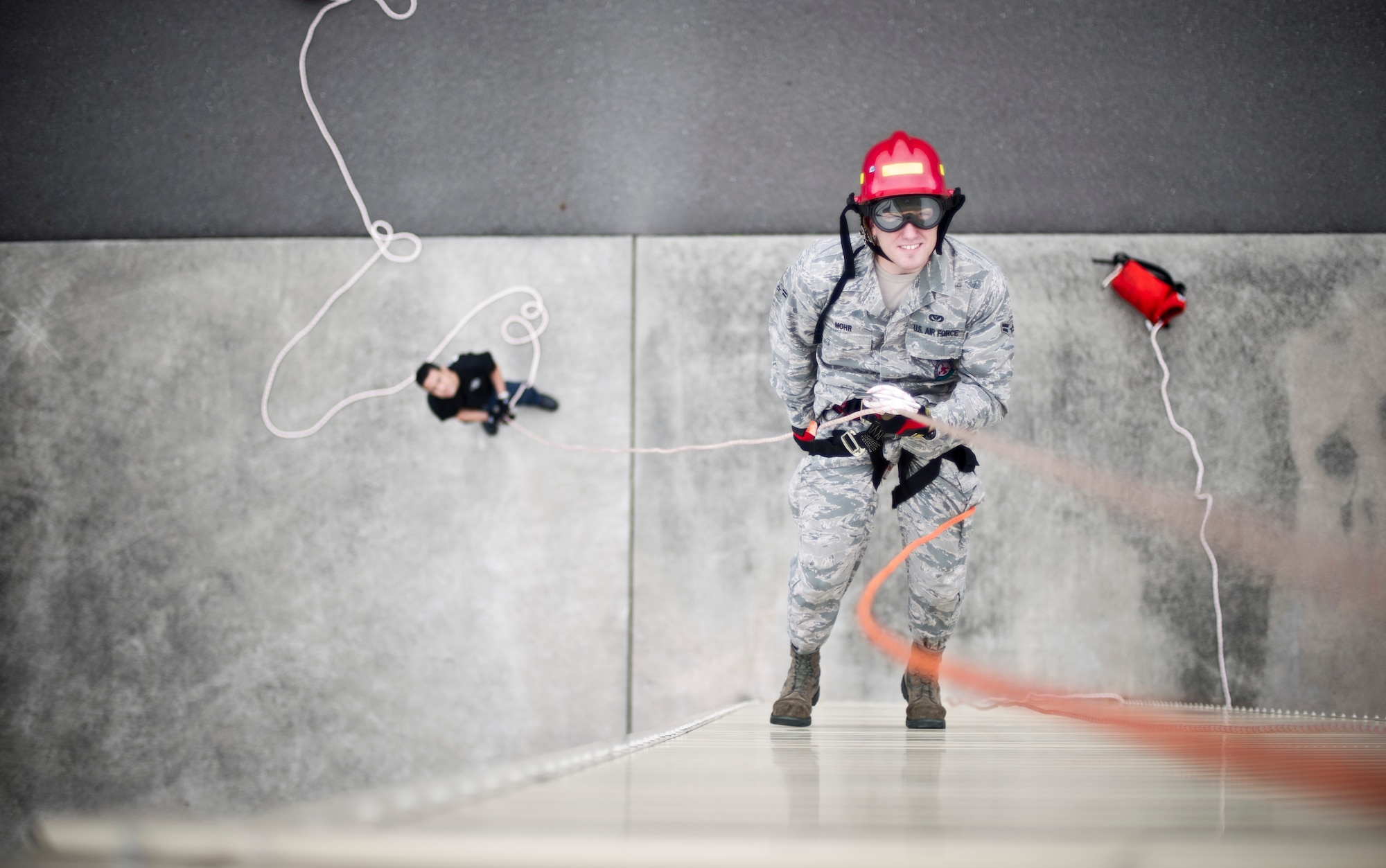 YOKOTA AIR BASE, Japan -- Airman 1st Class Nicholas Mohr, 374th Civil Engineer Squadron firefighter, performs high-angle training at Yokota Air Base, Japan, June 18, 2012. High-angle training requires the firefighters to rappel and save stranded victims to return them to safety. The training is an annual requirement for firefighters to stay proficient. This was Mohr’s first time negotiating the training wall at Yokota. (U.S. Air Force photo by Staff Sgt. Stacy Moless)