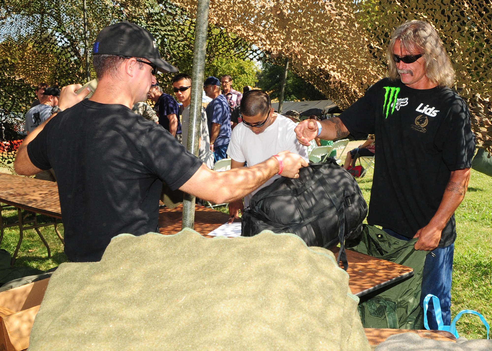 A volunteer from Beale Air Force Base, Calif., provides a new sleeping bag for Cole Young, a homeless U.S. Army veteran during the 2012 Veteran's Stand Down at River Bottoms Park in Marysville, Calif., August 24, 2012. The annual stand down provided basic needs, such as medical, financial, mental and religious services to veterans and their families and especially targeted homeless and less fortunate veterans. (U.S. Air Force photo by Senior Airman Shawn Nickel)