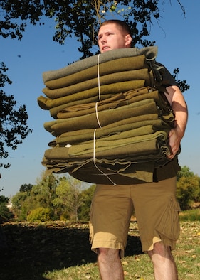 Airman 1st Class Christopher Hartford, 9th Communications Squadron, carries blackest while volunteering at the Veteran's Stand Down at River Bottoms Park in Marysville, Calif., August 24, 2012. The annual stand down provided basic needs, such as medical, financial, mental and religious services to veterans and their families and especially targeted homeless and less fortunate veterans.  (U.S. Air Force photo by Senior Airman Shawn Nickel)