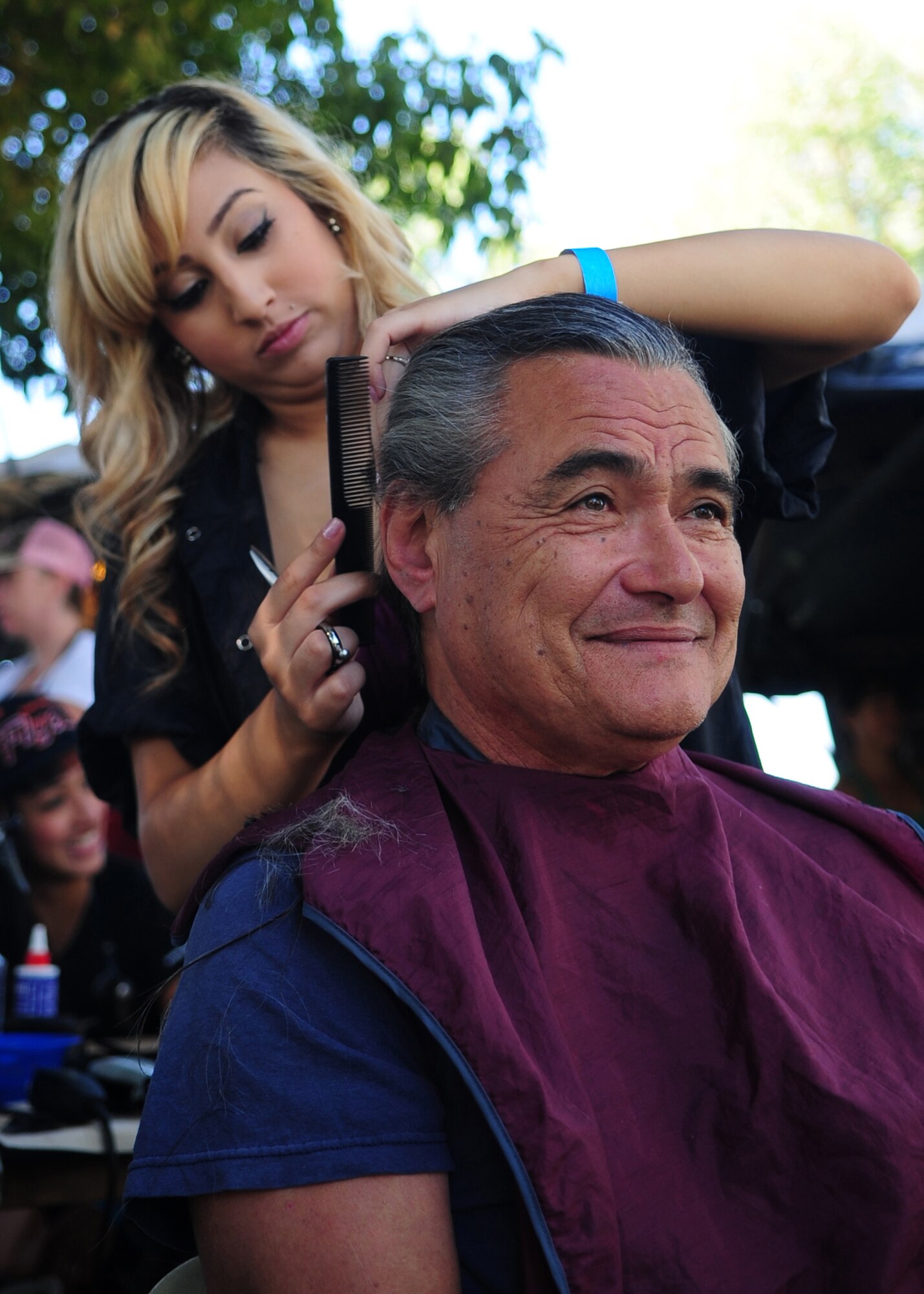 Patricia Gonzalez, from the Sacramento Federico Beauty Institute, cuts the hair of Steve Neisser, U.S. Army veteran, during the 2012 Veteran's Stand Down at River Bottoms Park in Marysville, Calif., August 24, 2012. The annual stand down provided basic needs, such as medical, financial, mental and religious services to veterans and their families and especially targeted homeless and less fortunate veterans. (U.S. Air Force photo by Senior Airman Shawn Nickel)