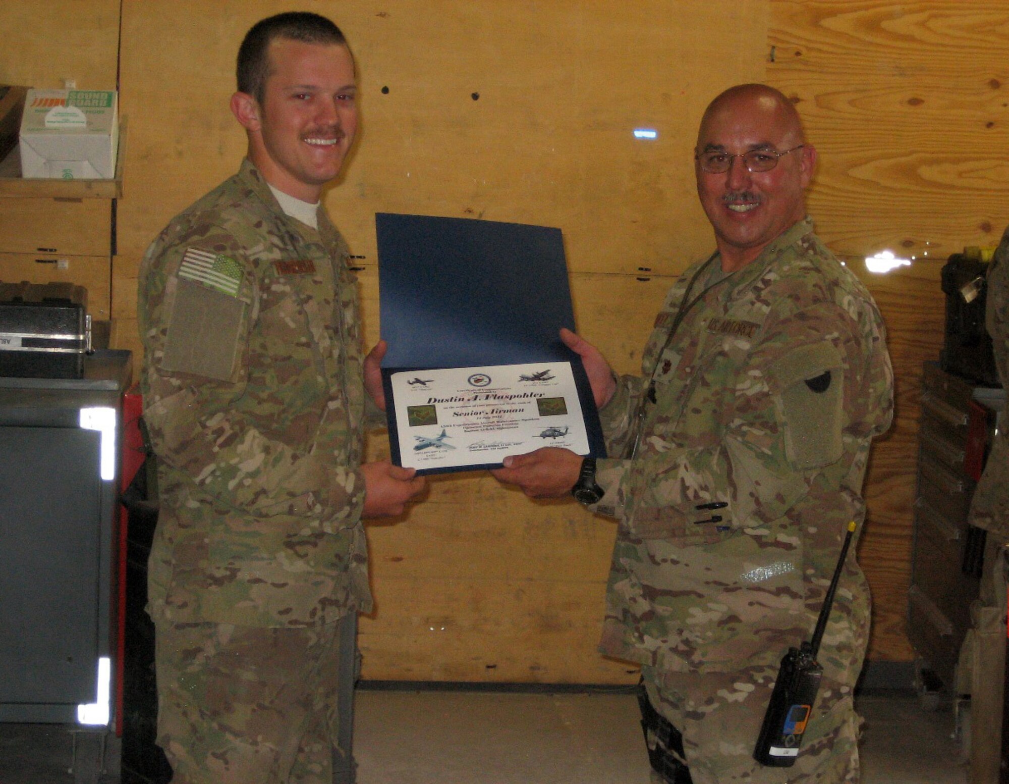 Senior Airman Dustin Flaspohler, left, receives a promotion certificate from Maj. John Easley at Bagram Airfield, Afghanistan. Both are members of the 188th Fighter Wing, which has approximately 375 Airmen currently deployed to Afghanistan in support of Operation Enduring Freedom. (Courtesy photo)