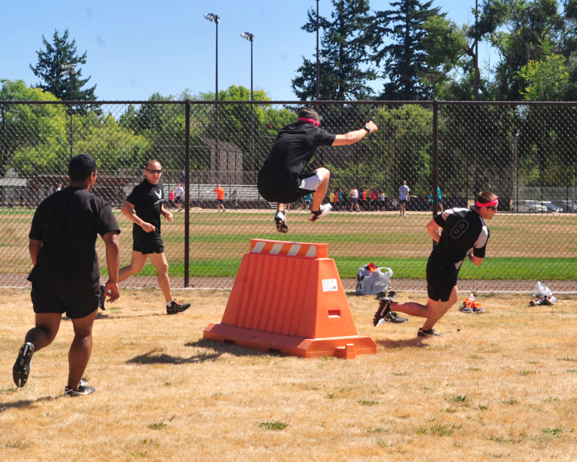 Members of the 5th Air Support Operations Squadron jump over obstacles as part of the combat relay race during Sports Day Aug. 24, 2012, at Joint Base Lewis-McChord, Wash. The 5th ASOS won this event. (U.S. Air Force photo/Staff Sgt. Frances Kriss)