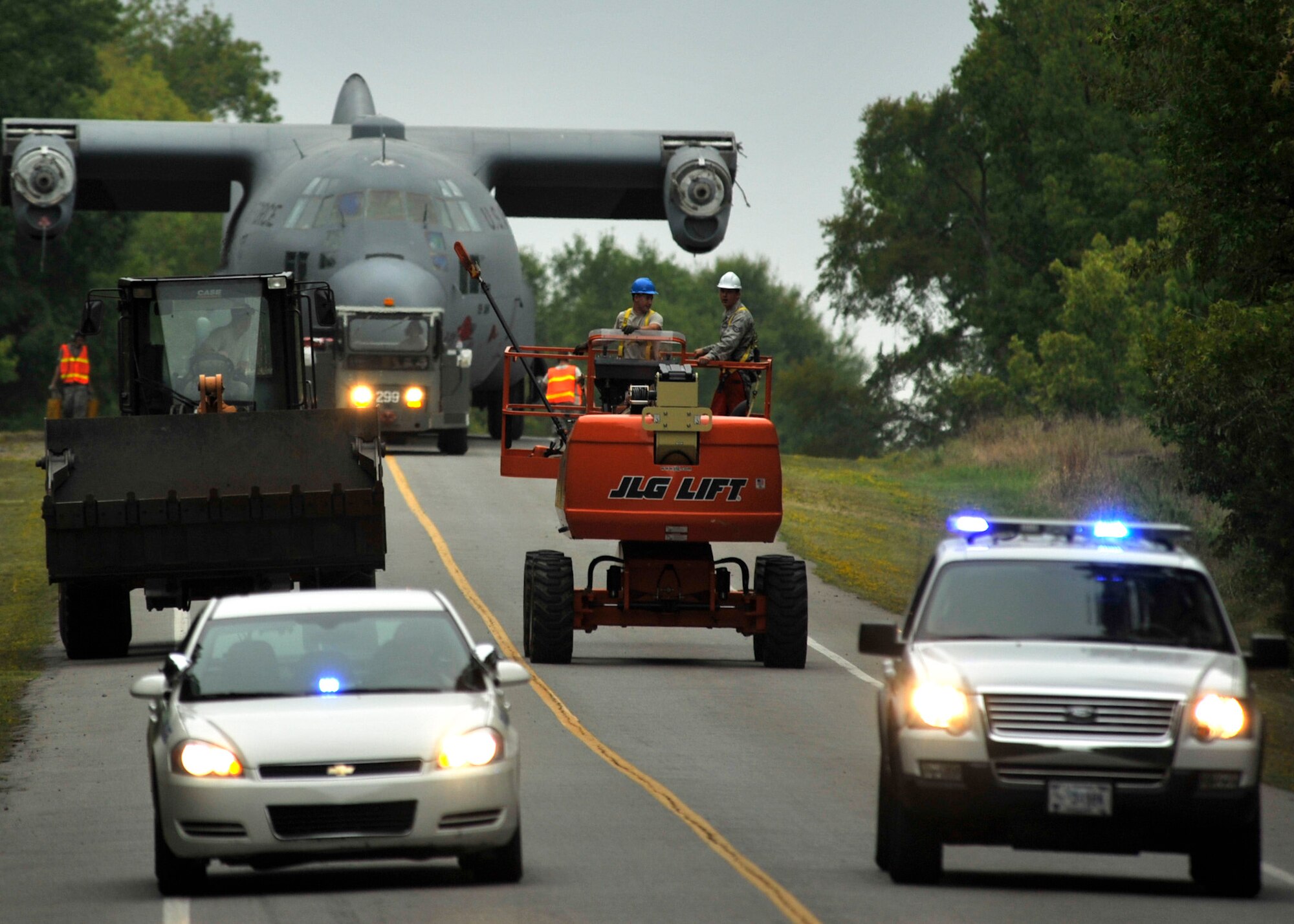 Members of the 19th Equipment Maintenance Squadron maintenance flight tow a C-130E to Marshall Road gate Aug. 25, 2012, at Little Rock Air Force Base, Ark. The C-130 will be a static display in front of Little Rock Air Force Base- City of Jacksonville Joint Education Center. (U.S. Air Force photo by Airman 1st Class Rusty Frank)