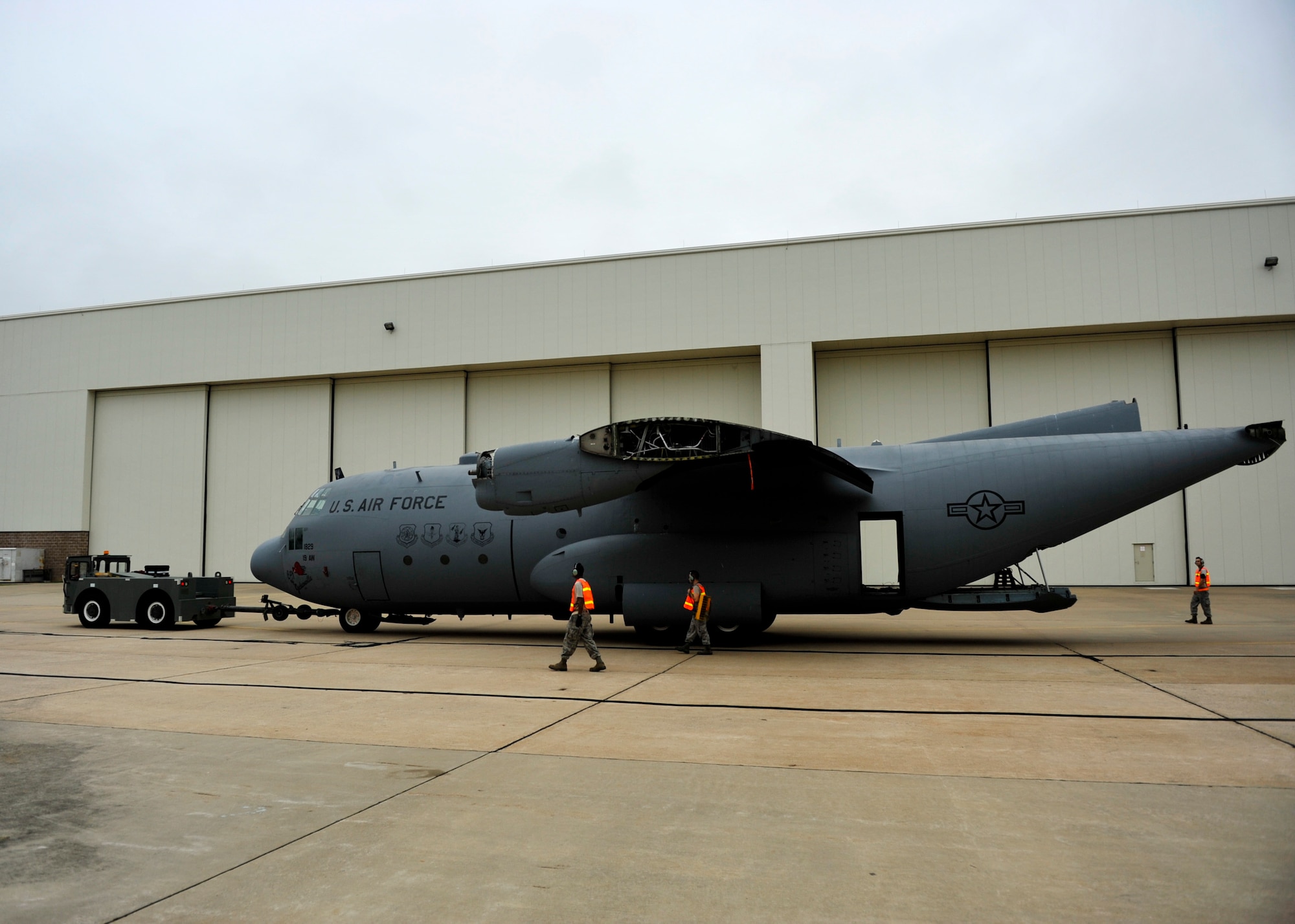 Members of the 19th Equipment Maintenance Squadron maintenance flight tow a C-130E in front of hangar 276 Aug. 25, 2012, at Little Rock Air Force Base, Ark. The C-130 has logged 24,479 airframe hours since its first duty assignment April 1, 1963, and is being retired in front of the Little Rock Air Force Base- City of Jacksonville Joint Education Center.  (U.S. Air Force photo by Airman 1st Class Rusty Frank)