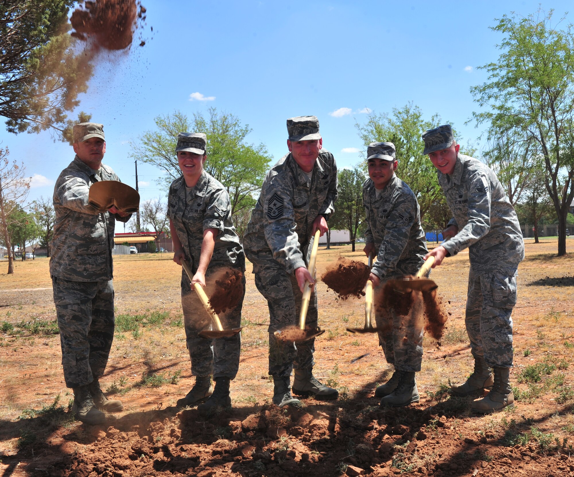 U.S. Air Force Tech. Sgt. Matthew Smith, 27th Special Operations Civil Engineer Squadron unaccompanied housing NCOIC, Airman 1st Class Samantha Crenshaw, 27th Special Operations Contracting Squadron contract specialist, Chief Master Sgt. Paul Henderson, 27th Special Operations Wing command chief, A1C Andrew Athanasiadis, 27th SOCONS contract specialist, and A1C Kyle Riess, 27th Special Operations Communications Squadron radio frequency transmissions systems apprentice, shovel out dirt during the ground breaking ceremony for new dormitories at Cannon Air Force Base, N.M., Aug. 27, 2012. The new dorms will alleviate many Airmen from having to live in double occupancy. (U.S. Air Force photo/Airman 1st Class Xavier Lockley)