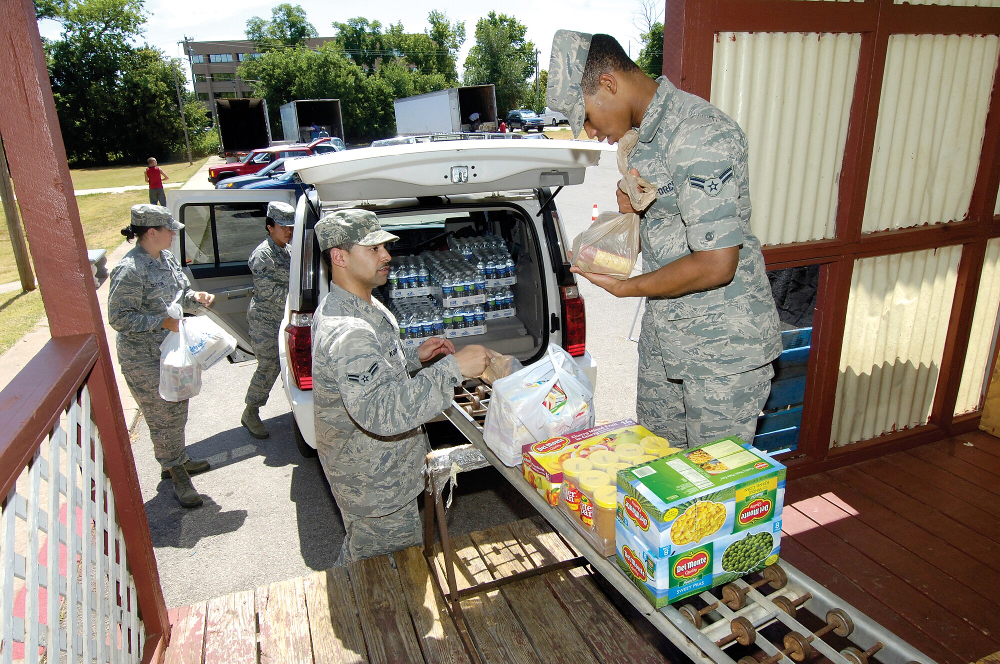 Tinker Airmen deliver donated food and water to the Mid-Del Food Pantry Aug. 20 after collecting the supplies from the base commissary donation box. The Feds Feed Families food drive is a response to a 2009 presidential act to foster relationships within communities and help the nation’s economic recovery.  Volunteers from the 72nd Force Support Squadron are, from back left; 1st Lt. Maegan Sutton, Airman 1st Class Maria Bianca Murillo, Airman 1st Class Aaron Kornegay and Airman 1st Class Wesley Preston. The Tinker Commissary has a collection box near the store entrance. Mid-Del Food Pantry representative Bonnie Waldrop thanked the Airmen as they unloaded the donations, saying the shelves had been looking a little bare and the need is greater this year although donations have been down.  (Air Force Photo by Margo Wright)