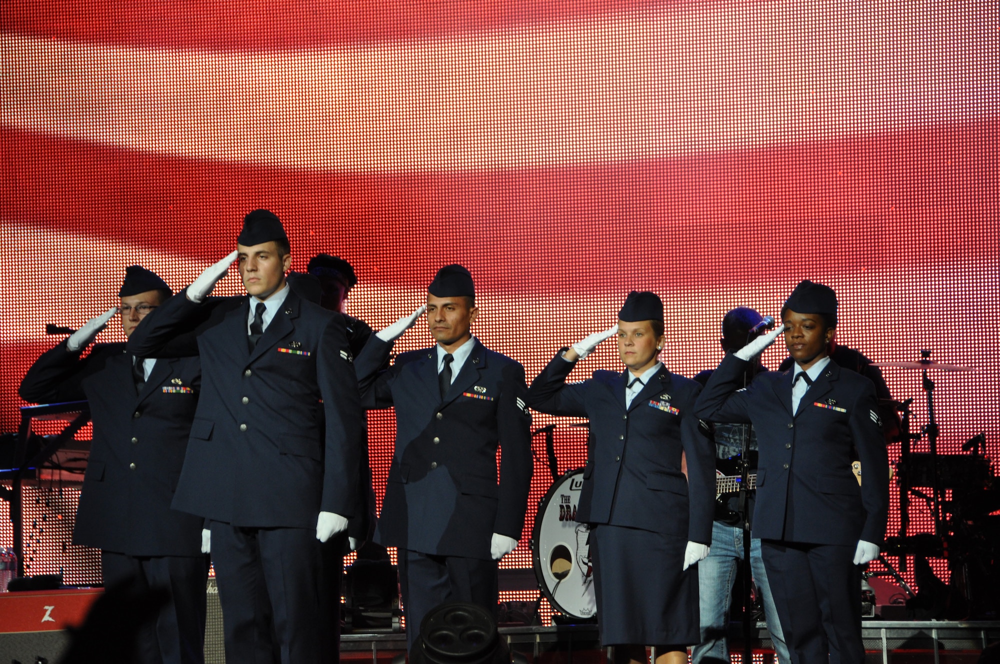 Airmen from the 69th Aerial Port Squadron salute the flag at the country music artist, Brad Paisley concert, Jiffy Lube Live Amphitheater, Bristow, Va., Aug. 25, 2012. The Airmen were invited to march on stage during Paisley’s song, “This is country music.” (U.S. Air Force photo/ Senior Airman Katie Spencer)