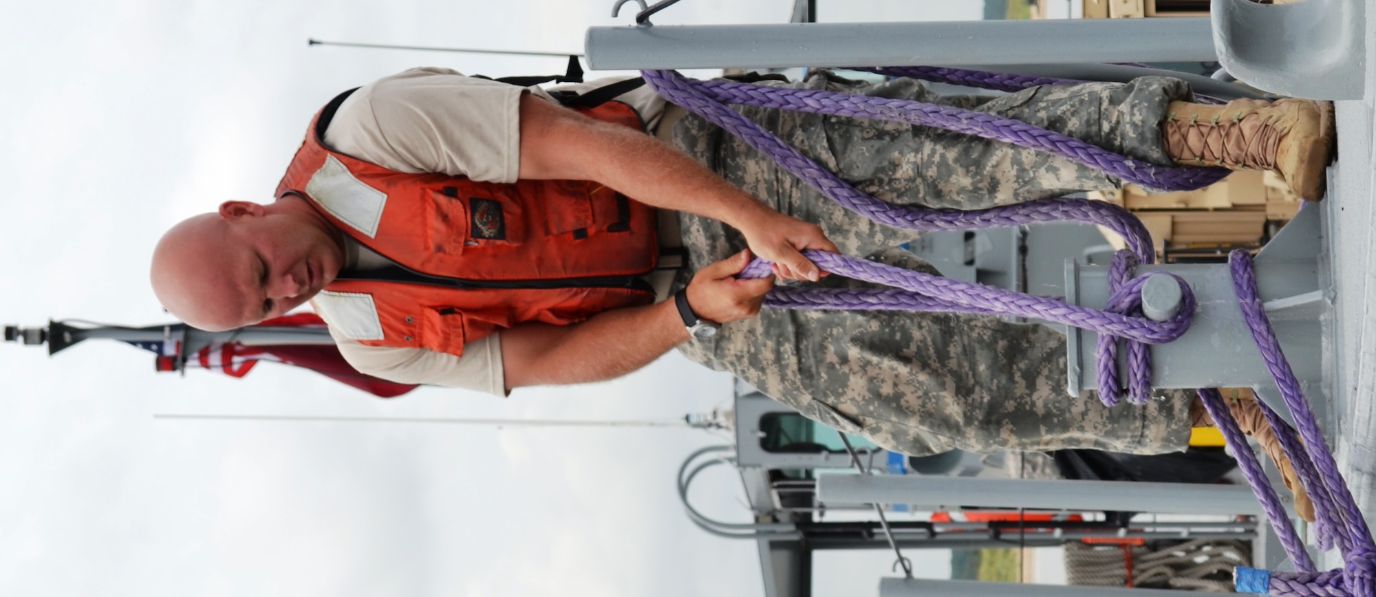 A 7th Sustainment Brigade Soldier secures the ties to his mike boat while docking during a Joint Logistics Over the Shore exercise at Fort Story, Va., Aug. 21. The JLOTS exercises are performed around the world in joint and coalition environments. Operations involve loading and unloading of ships without the benefit of deep draft-capable, fixed port facilities. (U.S. Army photo by Staff Sgt. Alexander Burnett/ Released)