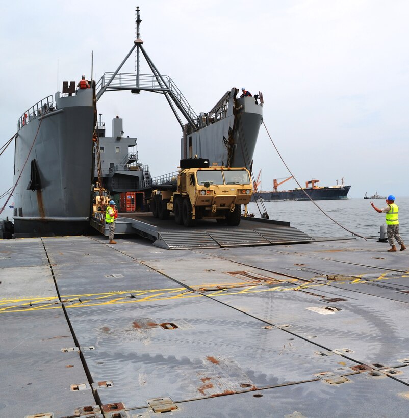 An Army Palletized Load System drives off the Logistics Support Vessel 1, Gen. Frank S. Besson Jr., and on to the main causeway during a Joint Logistics Over the Shore exercise at Fort Story, Va., Aug. 21. Operations involve loading and unloading of ships without the benefit of deep draft-capable, fixed port facilities. (U.S. Army photo by Staff Sgt. Alexander Burnett/ Released)