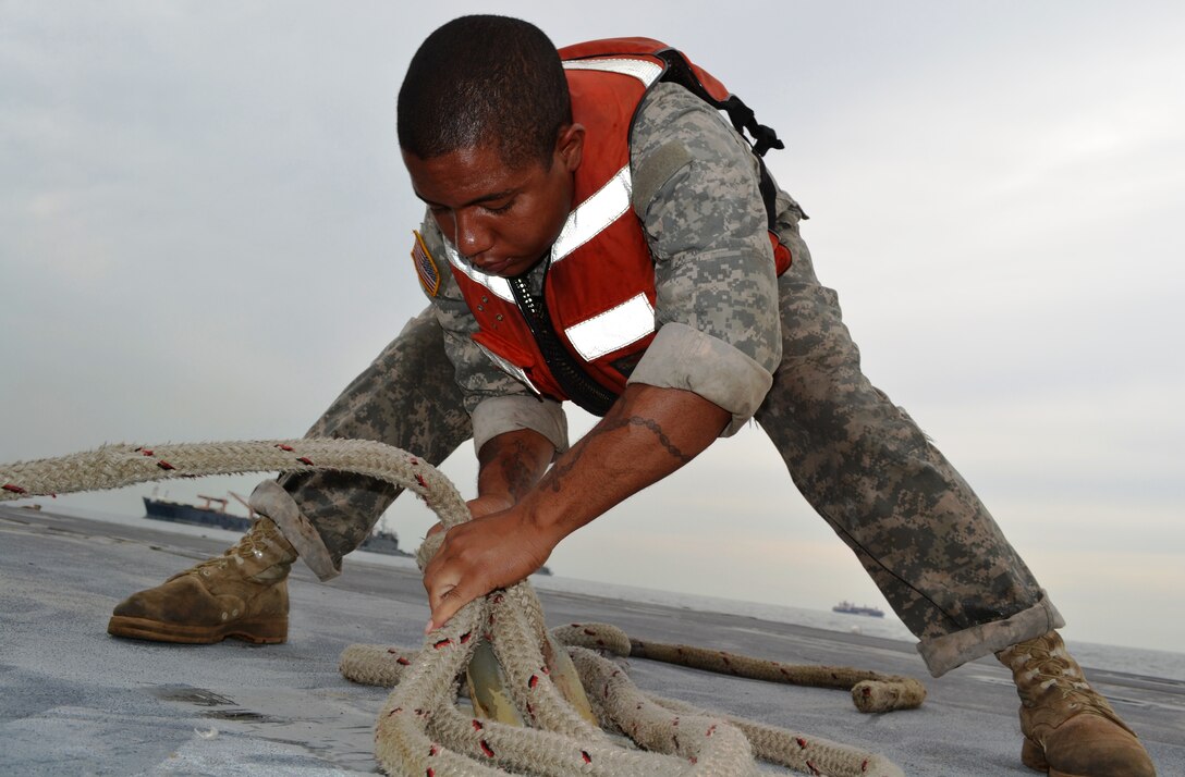 U.S. Army Pfc. Emmanuel Lopez, a watercraft operator assigned to the 331st Transportation Company, 10th Transportation Battalion, 7th Sustainment Brigade, unties his mike boat from the main causeway during a Joint Logistics Over the Shore exercise at Fort Story, Va., Aug. 21. The JLOTS exercises are performed around the world in joint and coalition environments. (U.S. Army photo by Staff Sgt. Alexander Burnett/ Released)