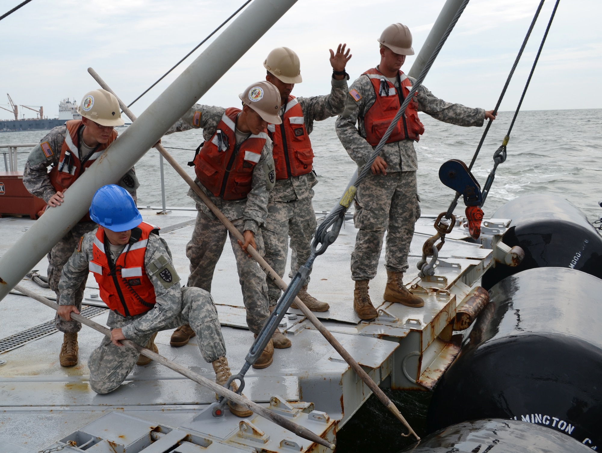 Soldiers assigned to the 7th Sustainment Brigade prepare to dock their vessel to the causeway during the Joint Logistics Over the Shore exercise at Fort Story, Va., Aug. 23. The JLOTS exercise is a chance for Army and Navy watercraft personnel to train together. (U.S. Army photo by Staff Sgt. Alexander Burnett/ Released)