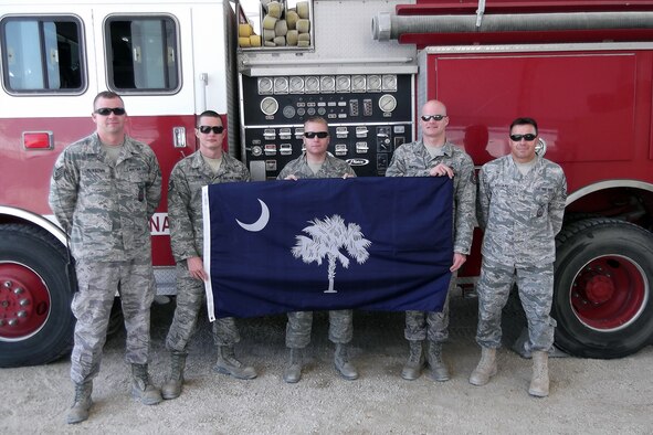 Tech. Sgt. Justin McKeown, Staff Sgt. Daniel Tatum, Staff Sgt. Scott Westmoreland, Tech. Sgt. Derek Hunter, and Master Sgt. Matthew Williams, fire fighters from the 169th Civil Engineering Squadron at McEntire Joint National Guard Base, S.C., pose for a photo in front of a fire truck while deployed to Bahrain, 2012.