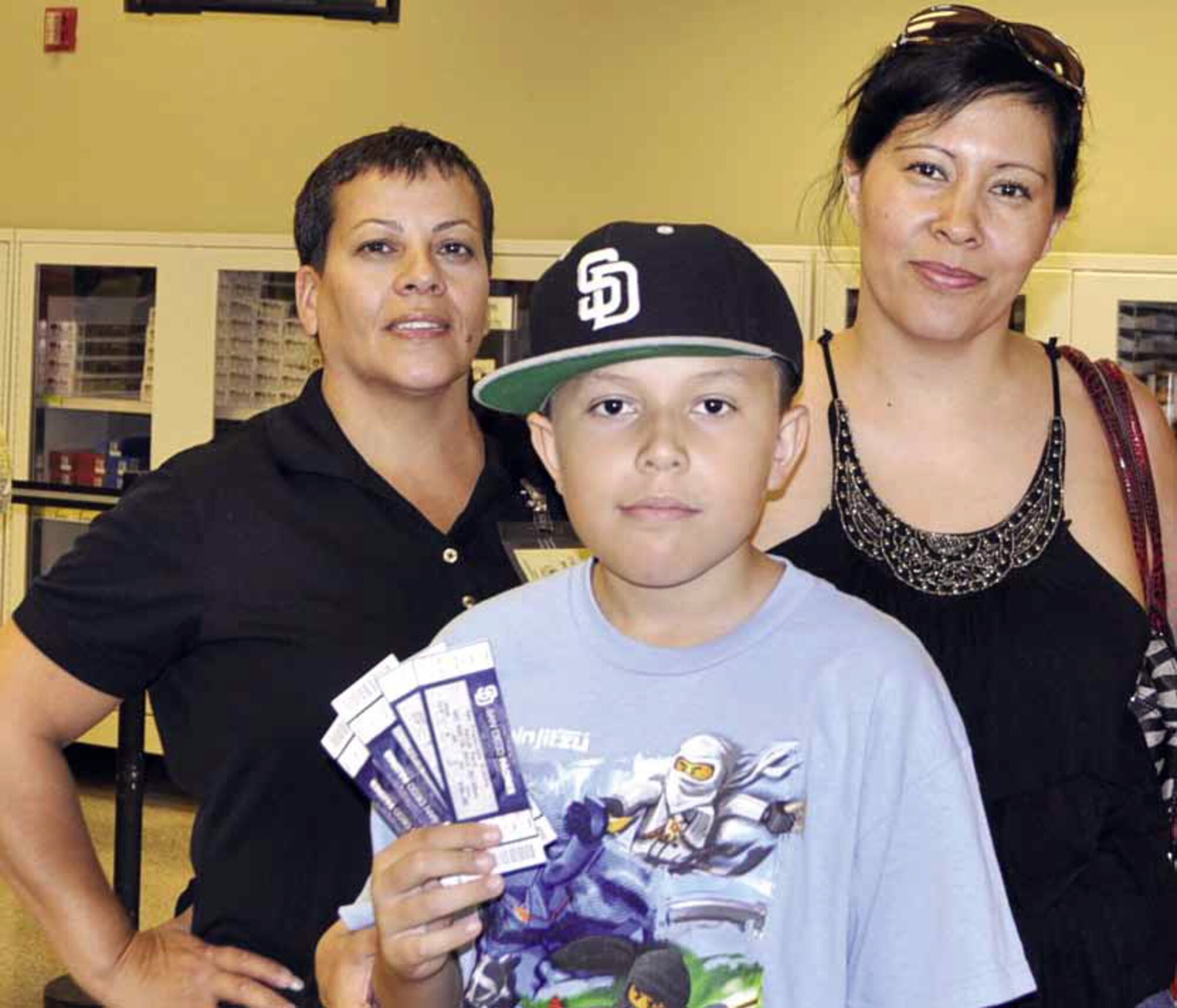 The March Air Reserve Base commissary held a grand reopening, Aug. 15, after 13 months of renovations. During the festivities, patrons enjoyed free food, drinks and special promotional gifts. William Johnson, Navy dependent, pictured with mother, Olivia (right) was the winner of four San Diego Padre baseball tickets. Lisa Martinez, left, Advantage sales representative, was on hand and donated 60 tickets on behalf of Unilever, a food, home and personal care product company. (U.S. Air Force photo by Linda Welz)
