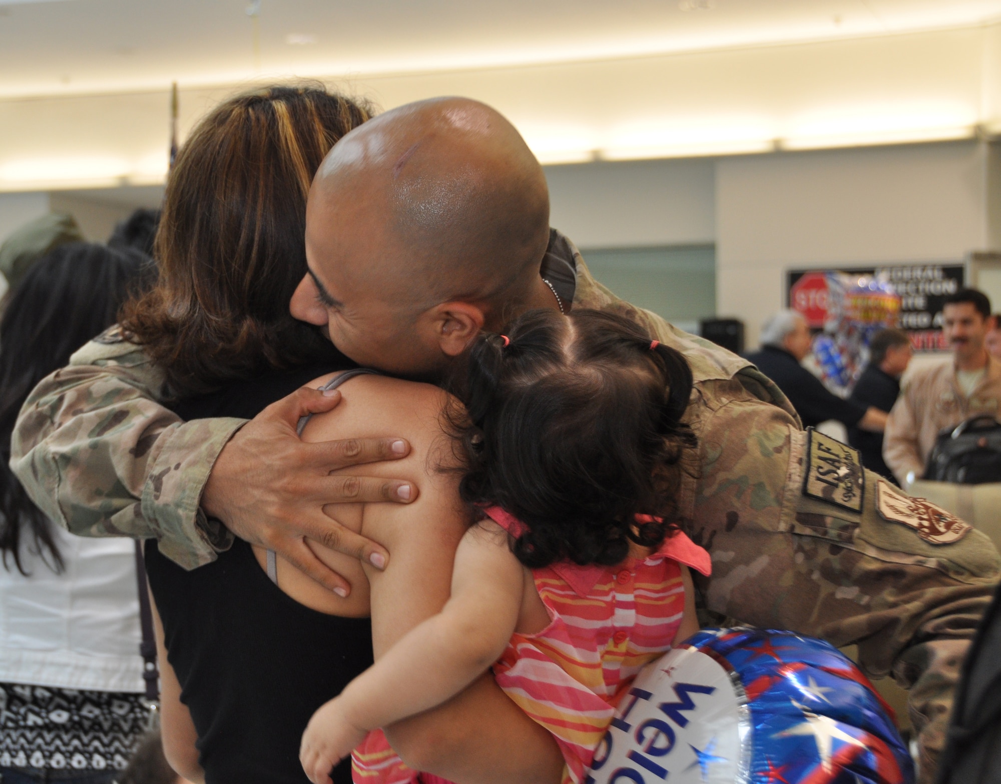 U.S. Air Force Master Sgt. Max Andrade, 69th Aerial Port Squadron, hugs his wife, Ana Andrade and daughter, Genesis, as he exits the terminal at Baltimore-Washington International Thurgood Marshall Airport, Md., Aug. 24, 2012. The 69 APS welcomed home 15 troops who were returning from a six-month deployment to Afghanistan. (U.S. Air Force photo/ Senior Airman Katie Spencer) 