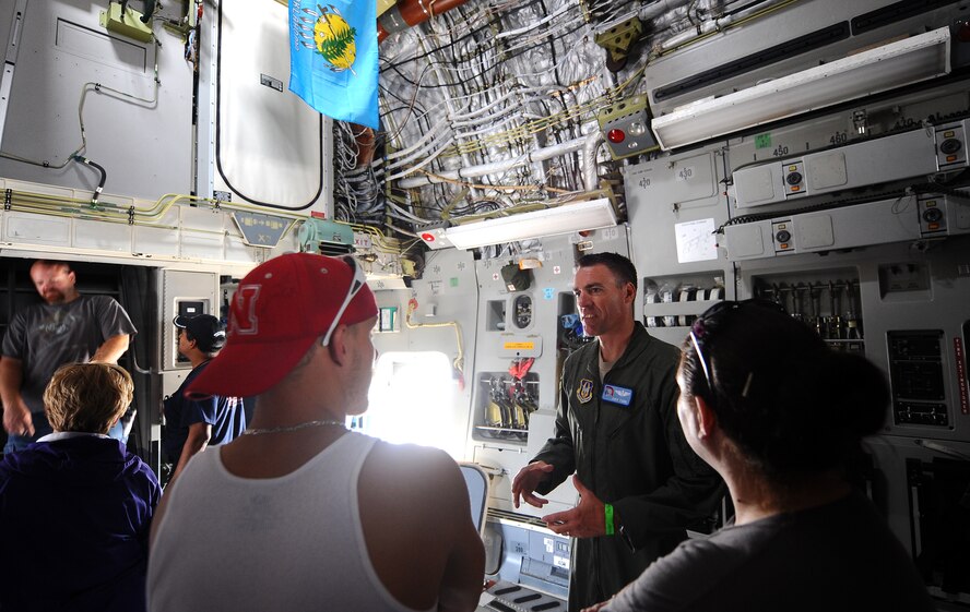 Maj. Jody Turk greets 2012 Defenders of Freedom Open House and Air Show guests as they tour the cavernous interior of a C-17 Globemaster from Altus Air Force Base, Okla., Aug. 26.  People waited in line to sit in the C-17 cockpit that allowed for an elevated view of the ramp.  (U.S. Air Force Photo by Josh Plueger/Released)