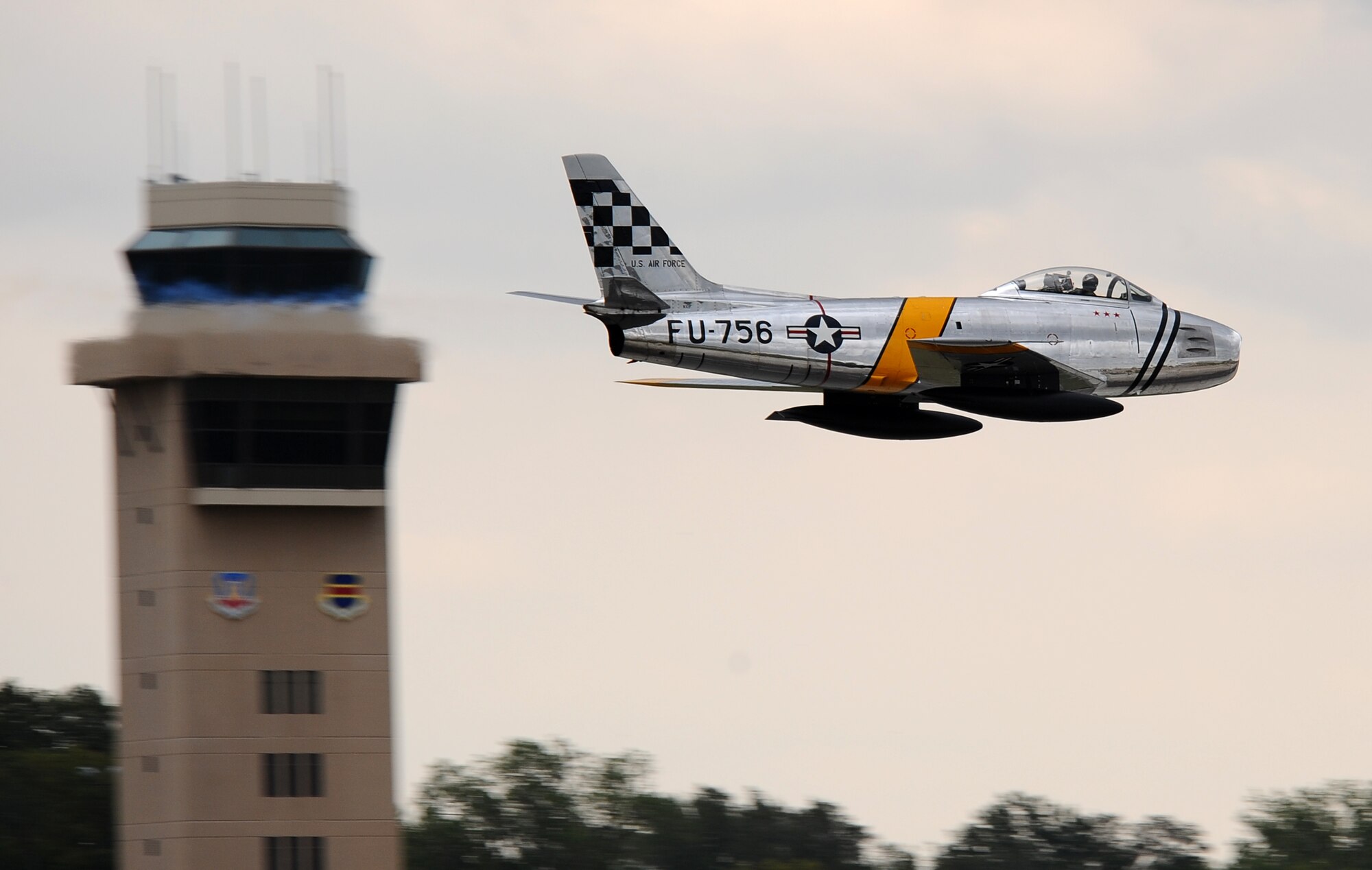 An F-86 Sabre flies by the control tower at Offutt Air Force Base, Neb., Aug. 24.  The practice air show on Friday allows special needs, Make-A-Wish and Wounded Warrior attendees to get a front row seat and meet with pilots and commanders.  (U.S. Air Force Photo by Josh Plueger/Released)