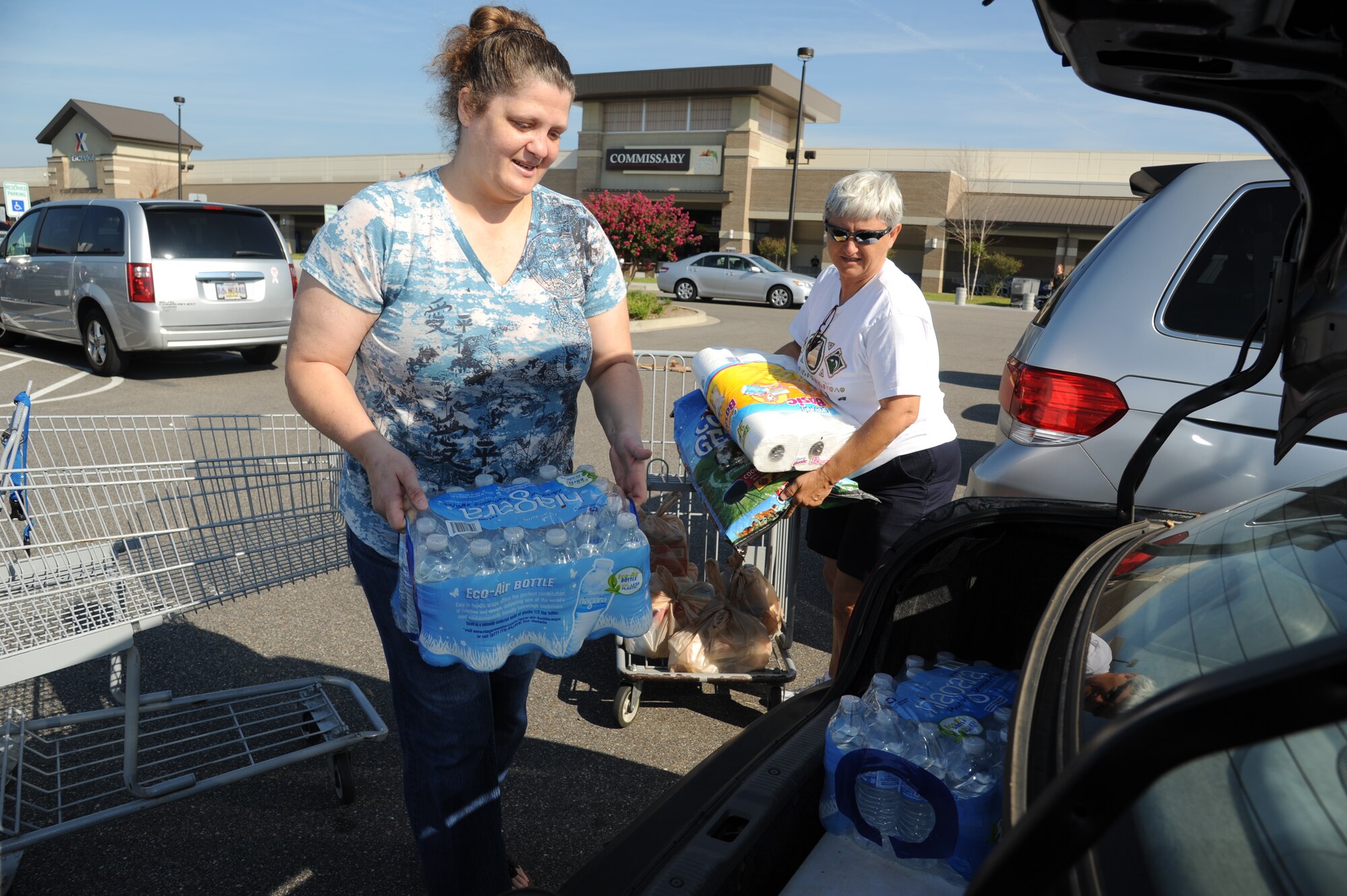 Darlene Gnuschke, Air Force retired and Biloxi resident, receives help from Maria Ainaga, head bagger at the base commissary with loading cases of water and other hurricane supplies into her trunk Aug. 27, 2012, at Keesler Air Force Base, Miss.  Keesler personnel are taking preventative measures to prepare and protect themselves and Keesler's assets as the base commander has declared HURCON 3, meaning destructive winds of 58 MPH or greater are expected as Hurricane Isaac approaches. (U.S. Air Force photo by Kemberly Groue)